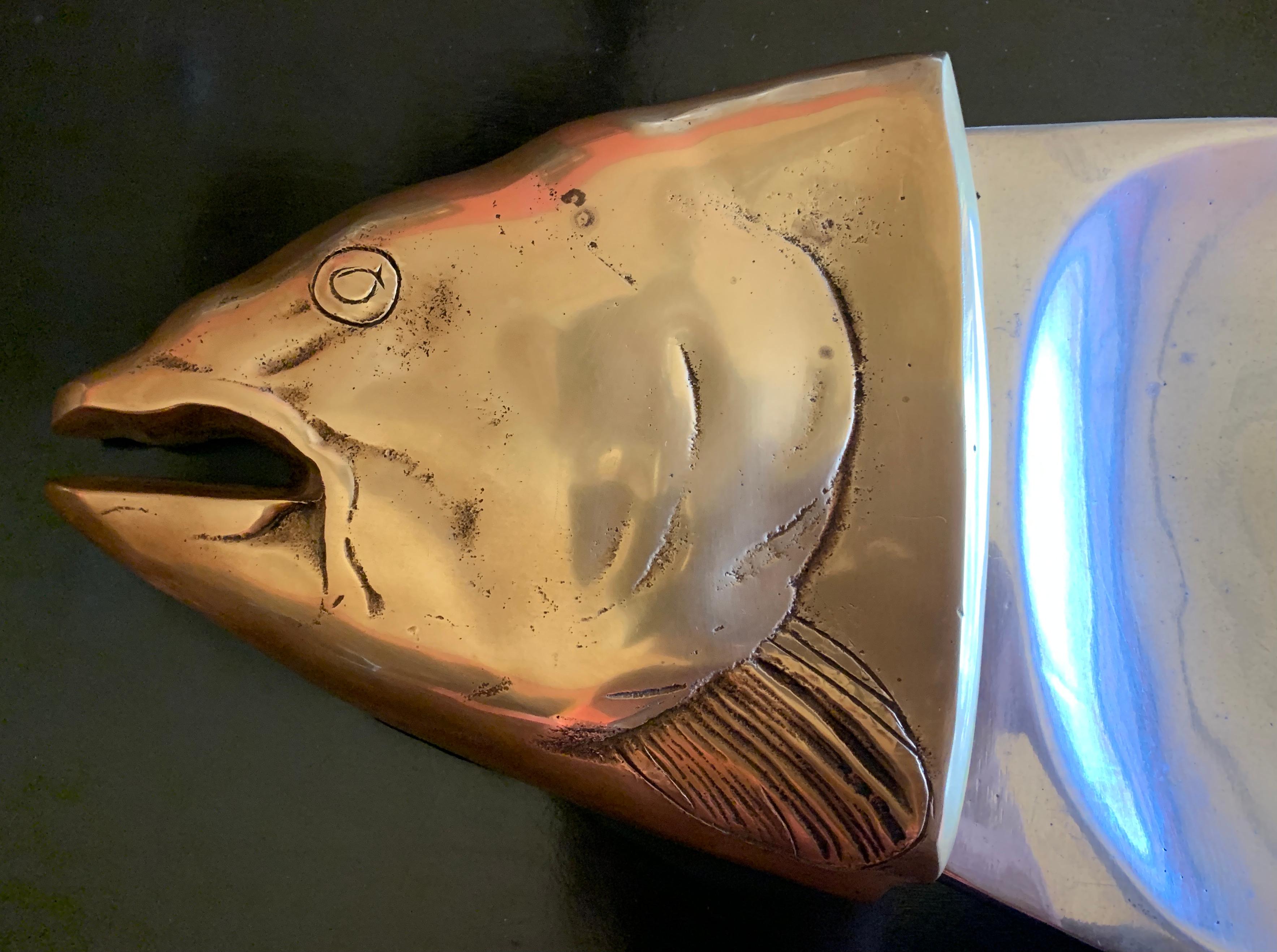 A wonderful and quite large fish platter! The Body is made of polished aluminum and the fishes head and tail are polished brass. 

This piece is truly spectacular - while a great serving piece for entertaining... the wonderfully designed aspects