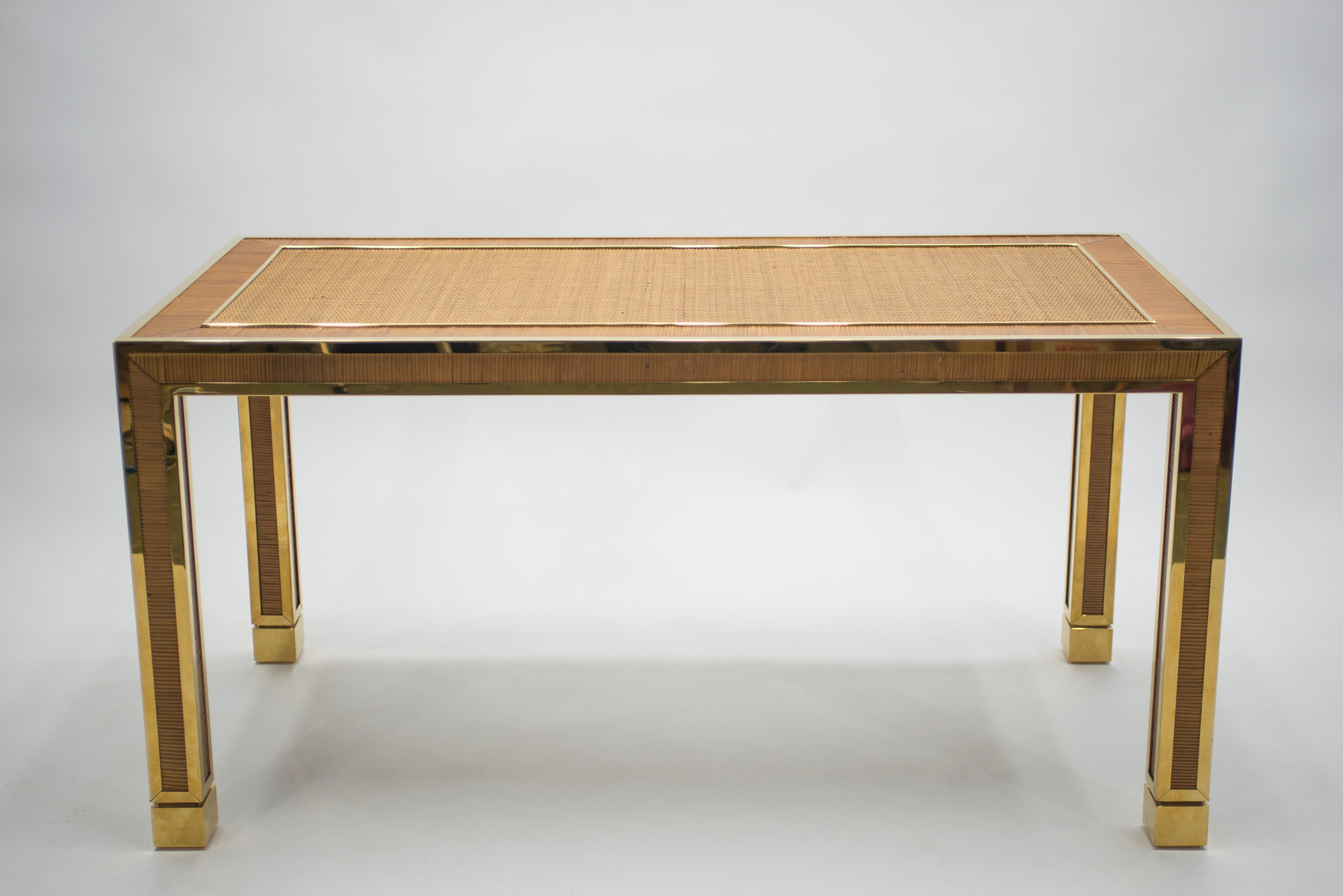 The designer of this small, light brown and golden dining table from the 1970s has managed to capture a warm and invigorating style. The structure of this piece is crafted from bamboo, lending it a natural texture and look. Gleaming brass accents