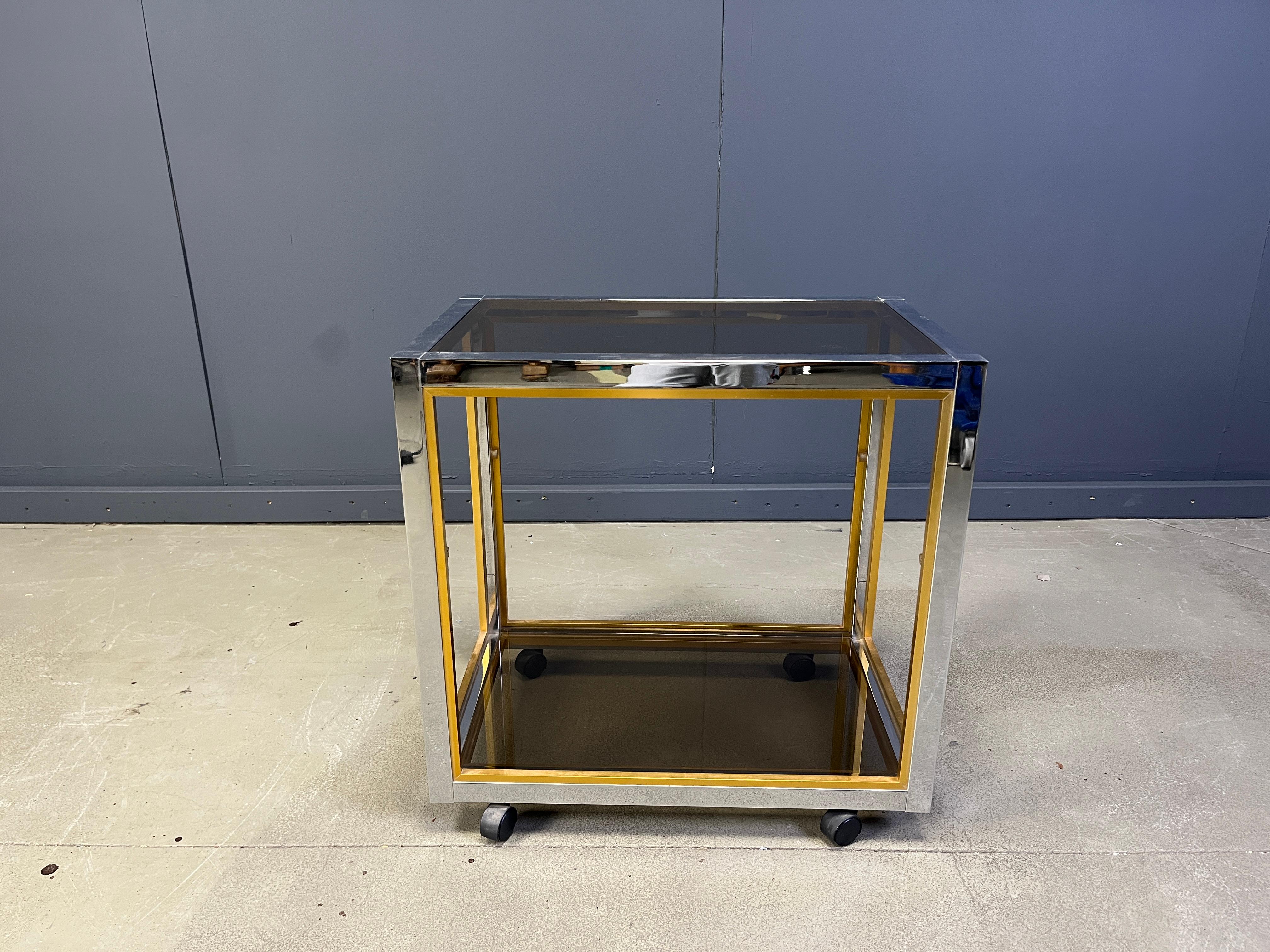 Vintage brass and chrome bar cart in the manner of Romeo Rega with smoked glass tops.

Cool contrasting chrome and brass frame.

Good condition with normal age related patina.

1970s - Italy

Labeled 'made in Italy'

Dimensions:
Height: 70cm
Width:
