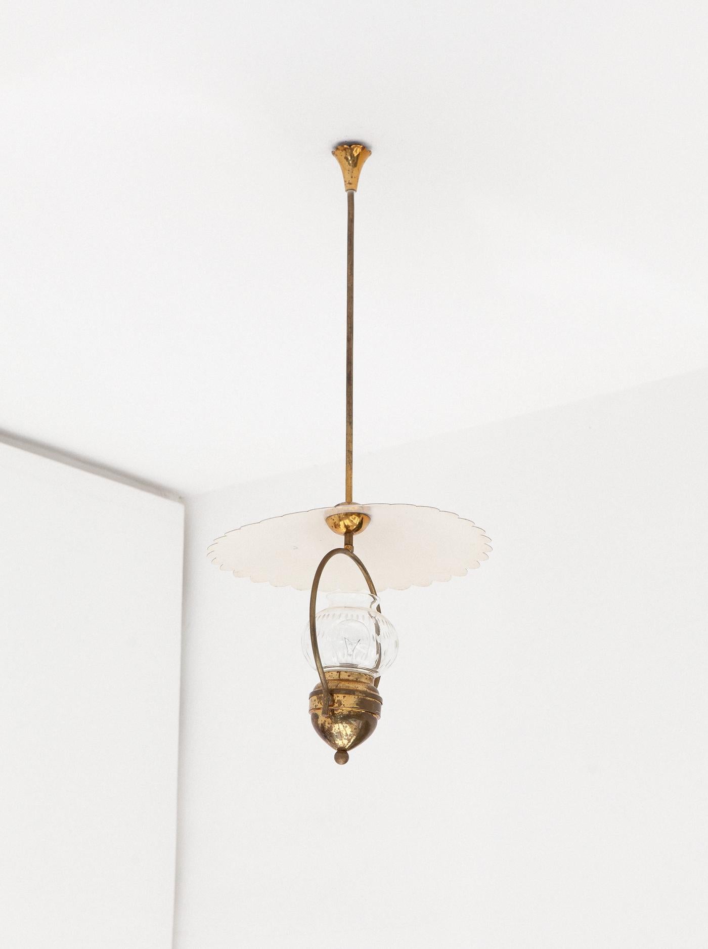 Mid-Century Modern pendant lamp, manufactured in Italy in the 1940s
This ceiling lamp is made of brass frame with its original patina, brass details, glass shade and metal white ivory enameled top.

Original working wire that mount standard E27