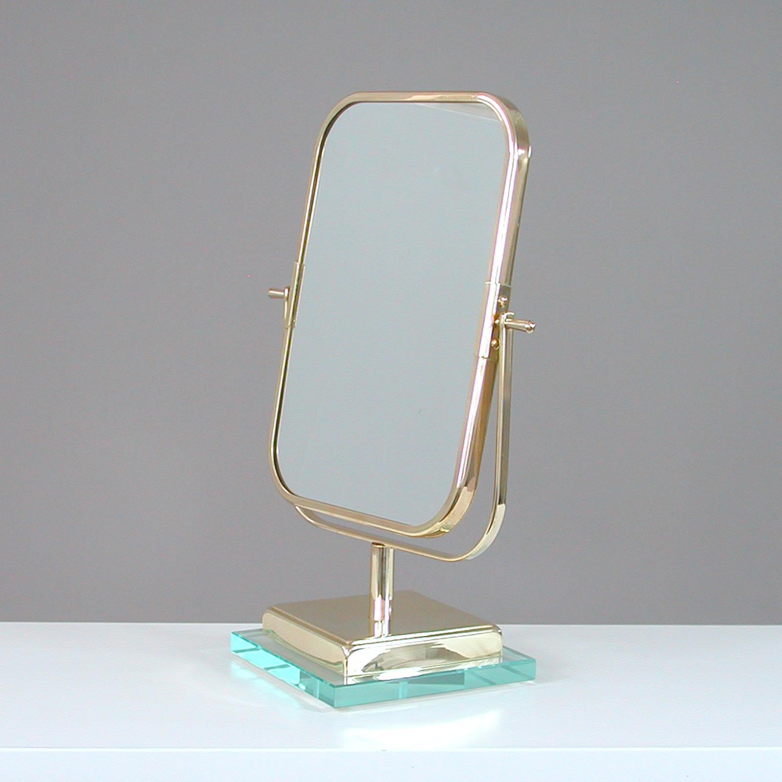This unusual vanity mirror was designed and manufactured in Italy in the 1950s in the Style of designer Gio Ponti for Fontana Arte.

The mirror features a thick polished glass base and brass frame. The mirror is adjustable with one rectangular