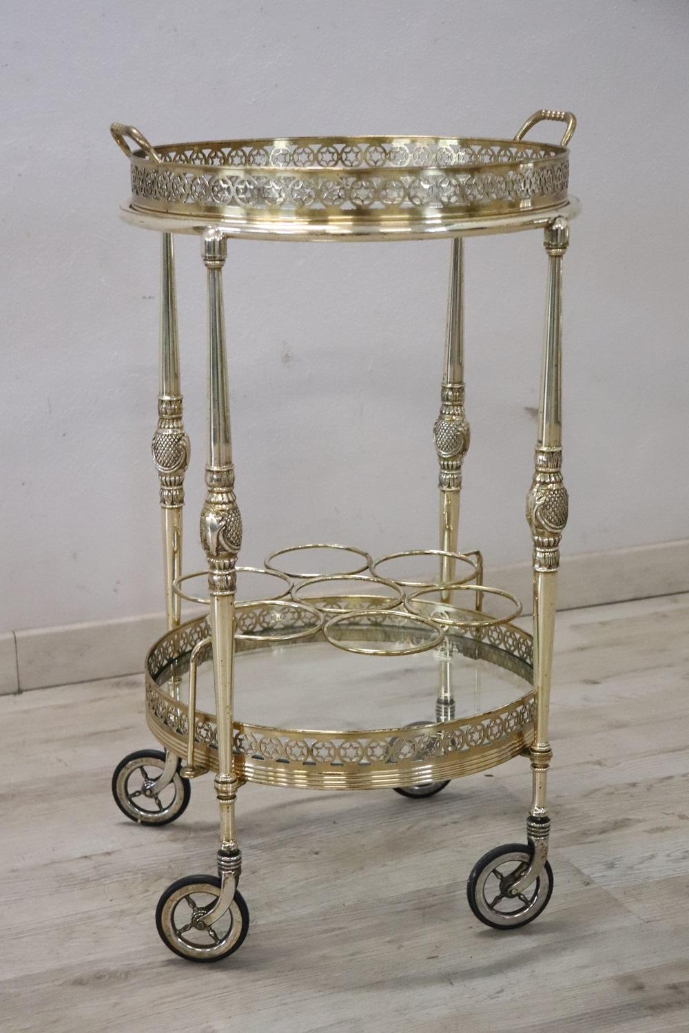 Rare drinks trolley Italian 1980s, it is made of golden brass and glass. The brass is finely worked. Comfortable wheels they allow easy movement. Equipped with one glass top, the top is equipped with handles and can be used as a tray to serve