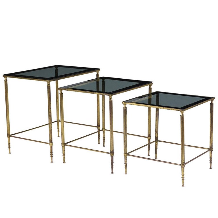 This Set of Mid Century Nesting Tables are in good condition, made out of solid brass, and come with their original tinted glass tops. The frames show so wear from age and use, so do the glass top but they do not have any major chips or scratches.