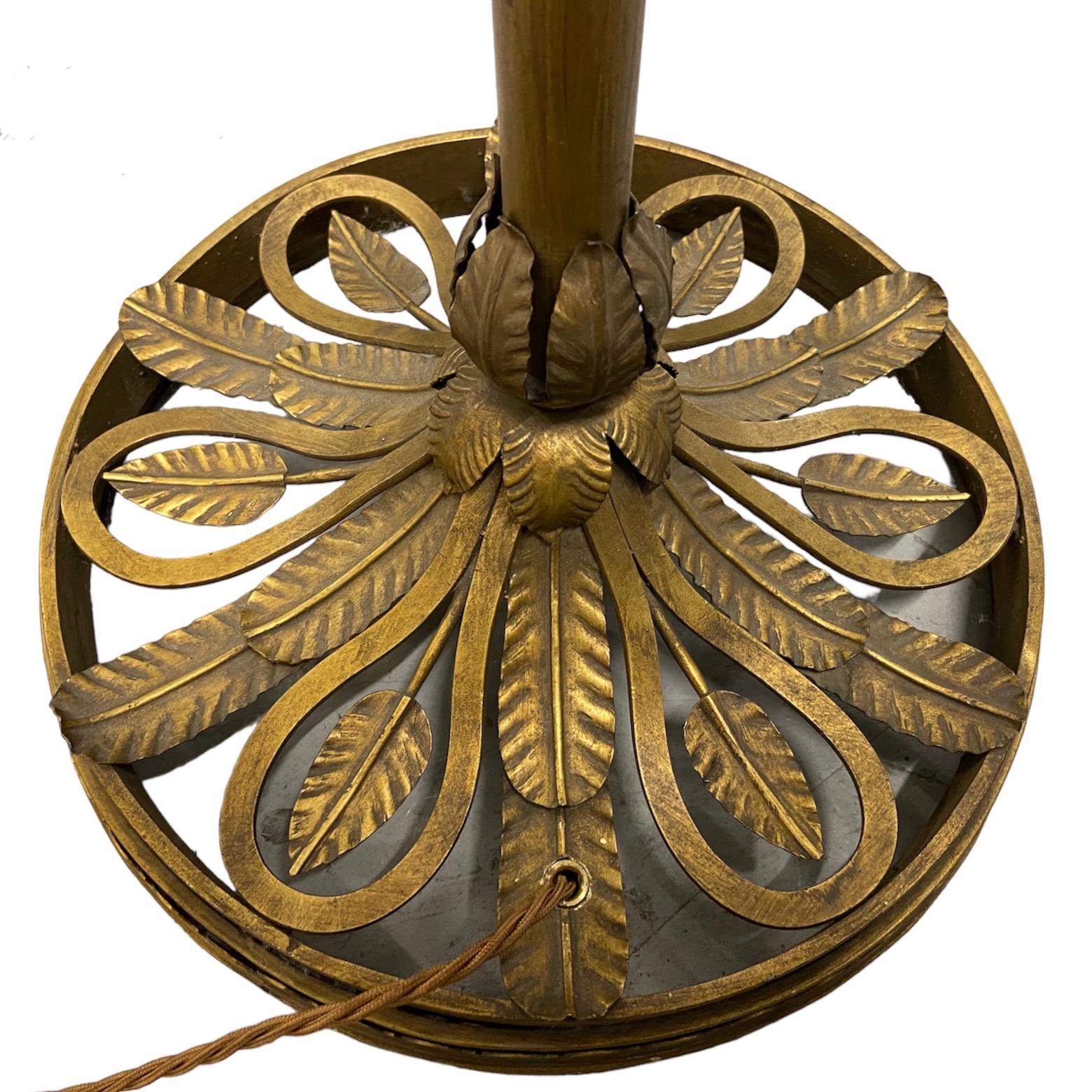 A balancing  brass and glass ornate, elegant and unusual floor lamp from around 1920's to 1950's. The crowned glass sphere hangs from the vertical tige by a brass branch.