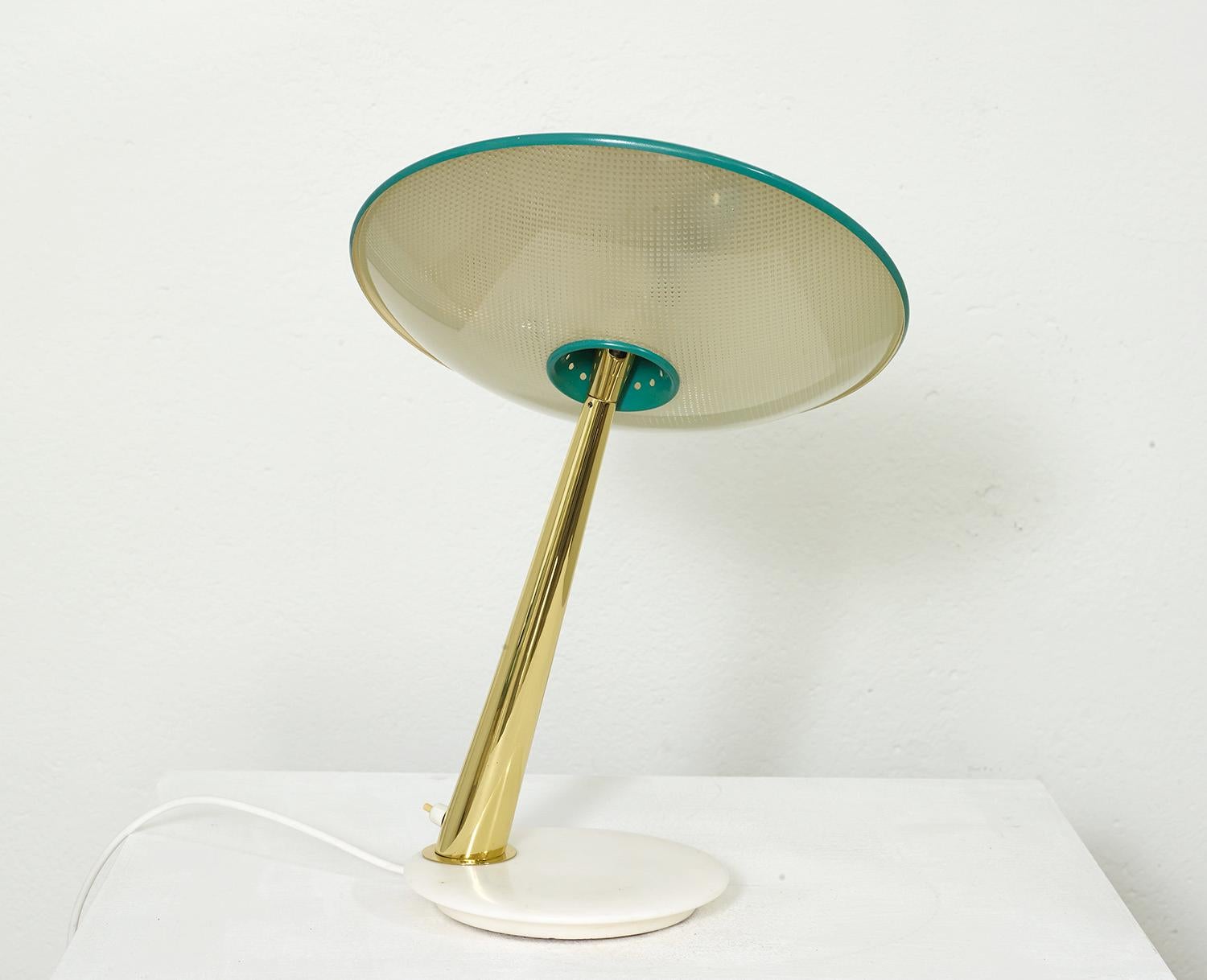 Italian brass and glass table lamp by Giuseppe Ostuni for Oluce, 1950.

This gorgeous table lamp has a round marble base with a brass stem and an adjustable saucer shaped reflector. The reflector is composed of an embossed glass diffuser and a