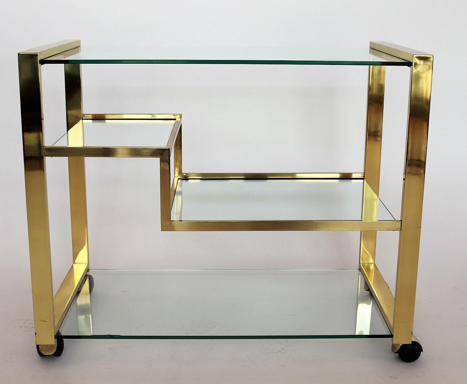 Beautiful bar cart or trolley made of full shiny brass and strong glass plates.
Made in the Hollywood Regency style of the 1970s in Italy.
The 4 rollers are working smoothly.
The trolley is in very good vintage condition.