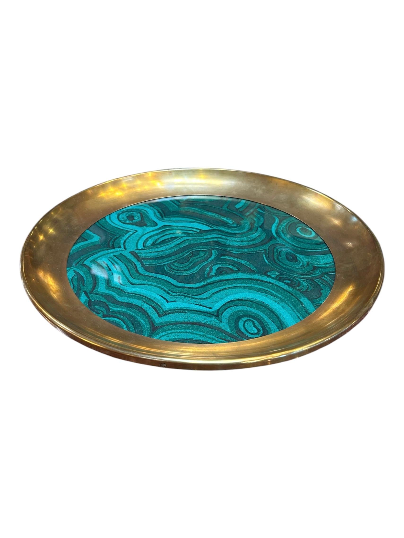 Esta llamativa bandeja italiana presenta un borde de latón pulido que enmarca un vibrante centro de malaquita con motivos verdes arremolinados. Su atrevido contraste de colores y su elegante acabado la convierten en una pieza decorativa destacada,