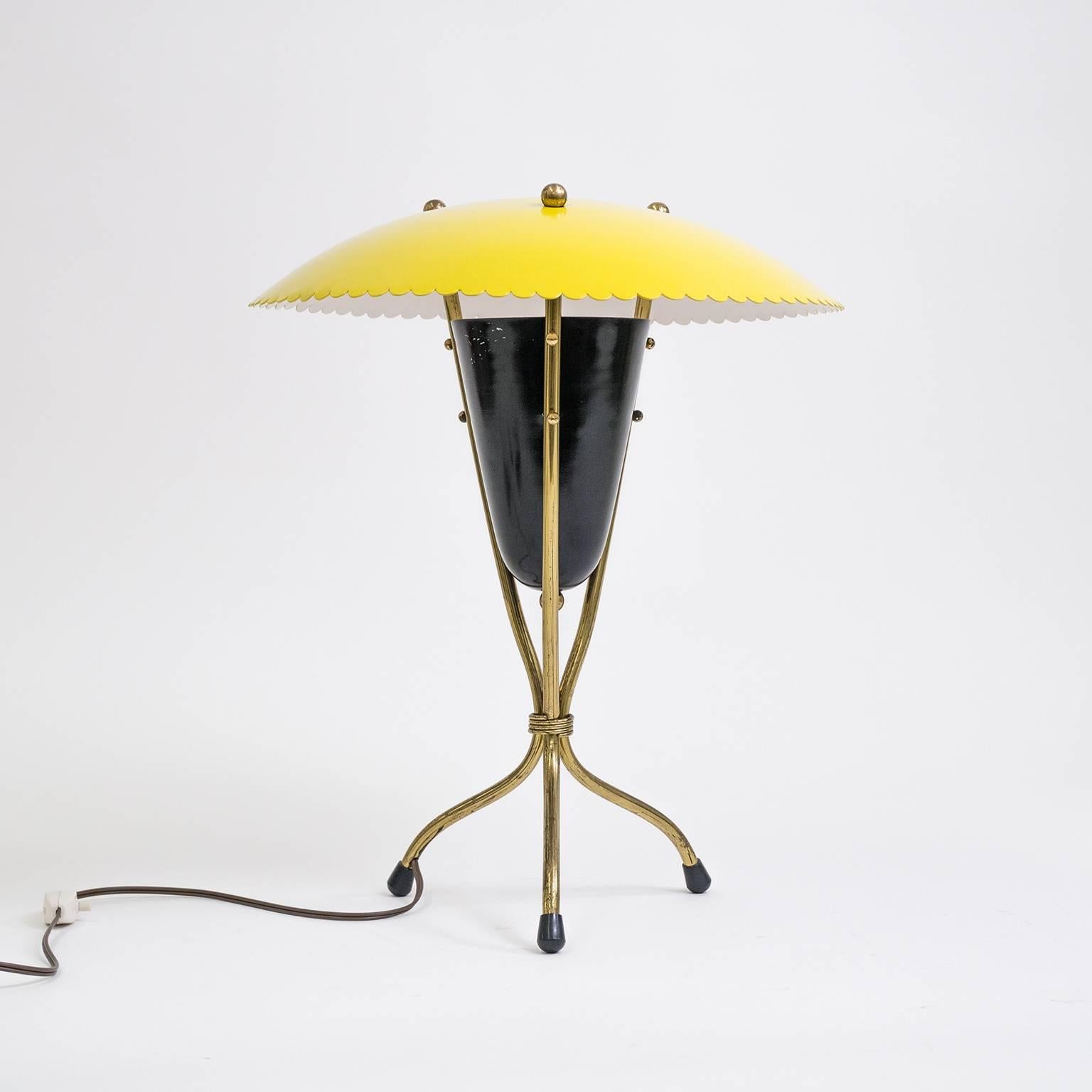 Charming midcentury Italian tripod table or desk lamp in brass and lacquered aluminium. The central black cone houses the light source which is reflected off the large scalloped shade for a soft indirect light. Very nice condition with a lovely