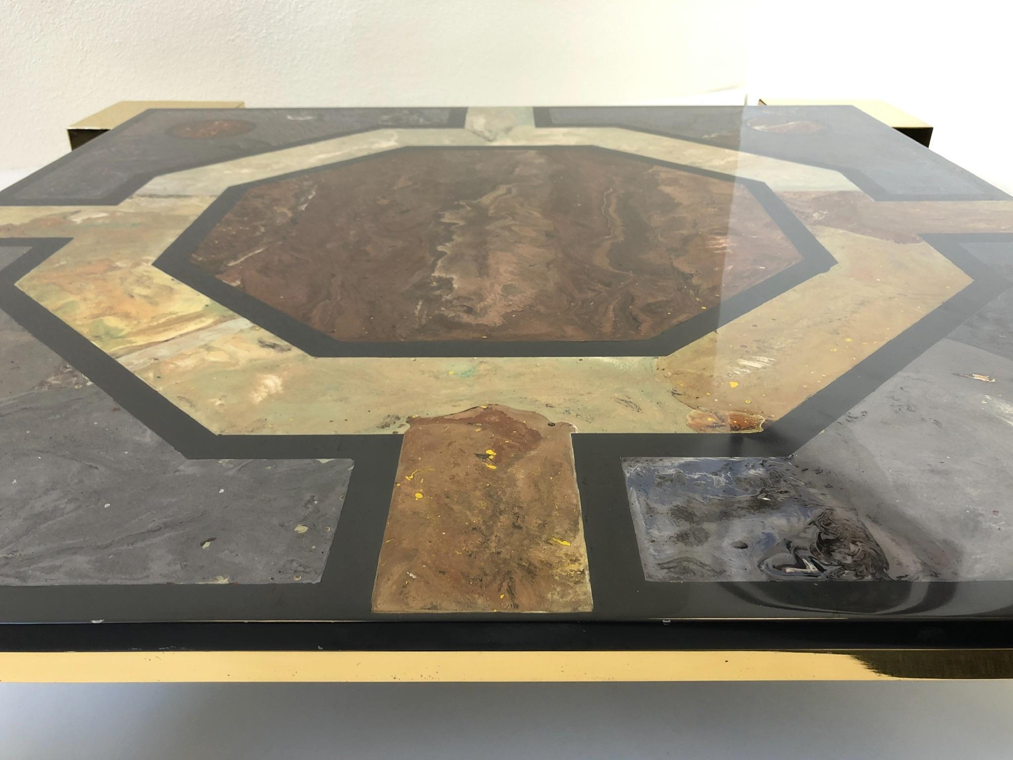 A spectacular Italian polish brass and marbleized inlaid design on a 43.5” wide 43.5” deep black slate top. The table was designed by Italian designer Marcello Mioni in the 1980s. The table has be professionally polished. Overall dimensions: 49”