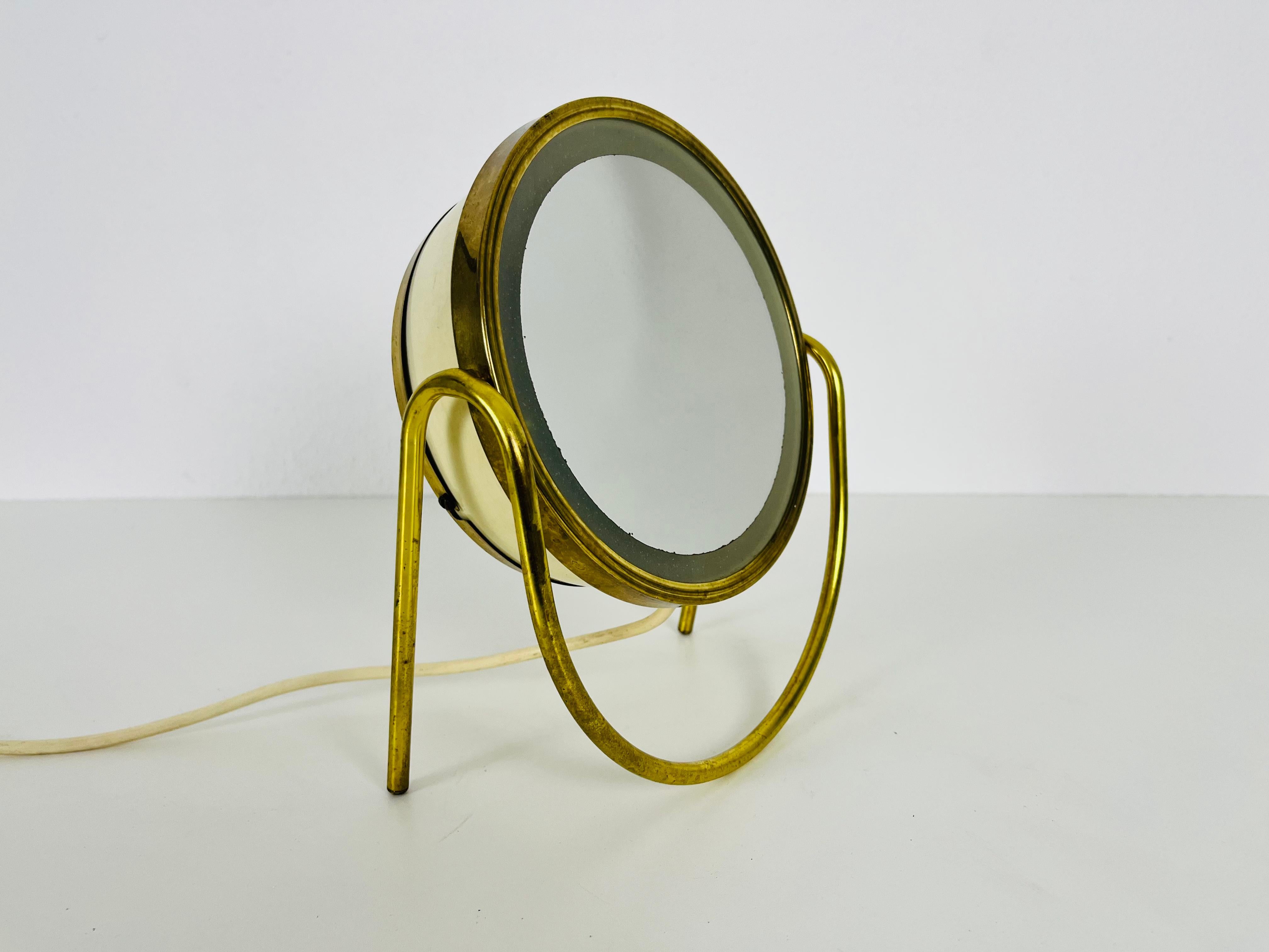 An illuminated Italian table mirror with brass legs. Beautiful with its amazing design.

 