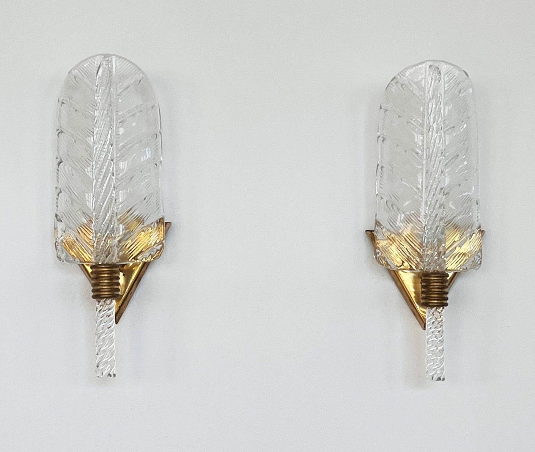 Beautiful set of two gorgeous brass wall lamps made of strong brass base and shiny transparent Murano glass leaves. Made in the style of Barovier and Toso. 
The beautiful hand-crafted glasses seem to be textured, please look carefully to all