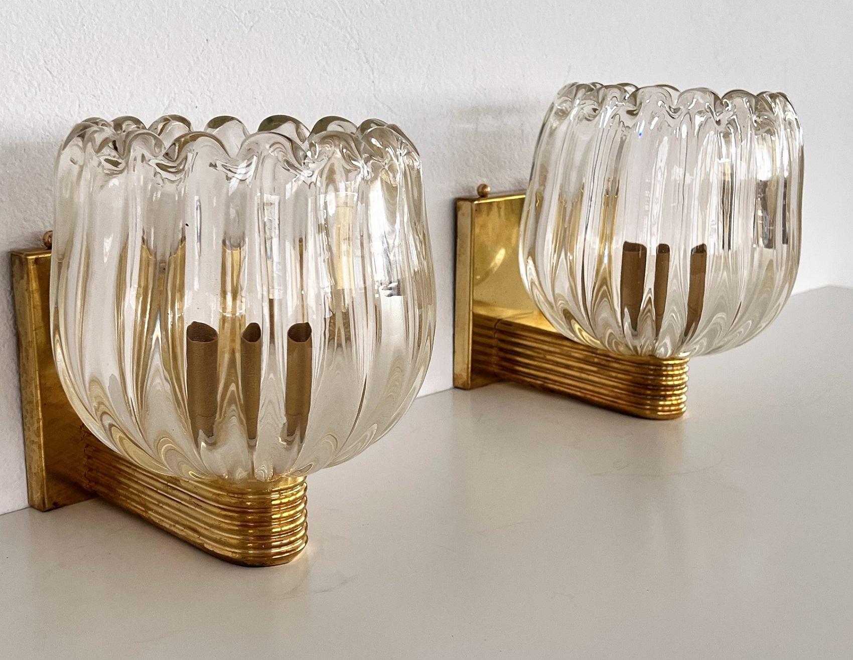 Beautiful set of two gorgeous brass wall lamps made of strong brass base and light amber-transparent Murano glasses with golden shimmer/glitter inside the glass. Art Deco style.
Made in Murano, Venice, Italy.
The brass is partially with gorgeous