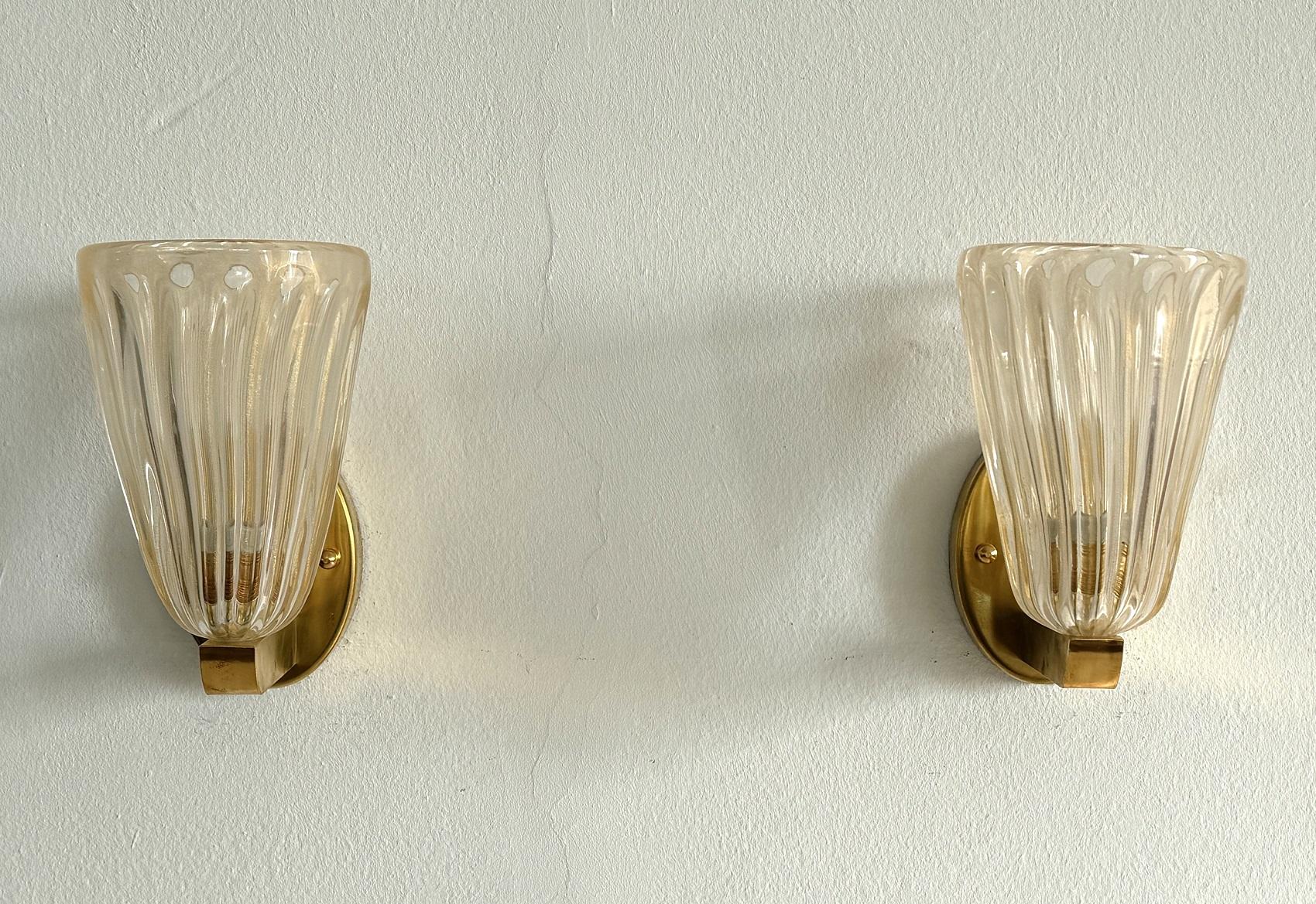 Italian Brass and Murano Glass Wall Lights or Sconces in Art Deco Style, 1990s

Beautiful set of two gorgeous brass wall lamps made of strong brass base and light amber colored Murano glasses with golden shimmer/glitter inside the glass. Art Deco
