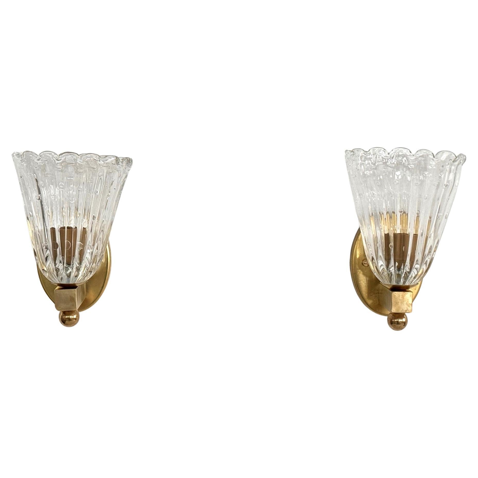 Italian Brass and Murano Glass Wall Lights or Sconces in Art Deco Style, 1990s

Beautiful set of two gorgeous wall lamps made of transparent thick Murano glasses with small air bubbles inside the glasses and strong brass base. 
Art Deco style. Made
