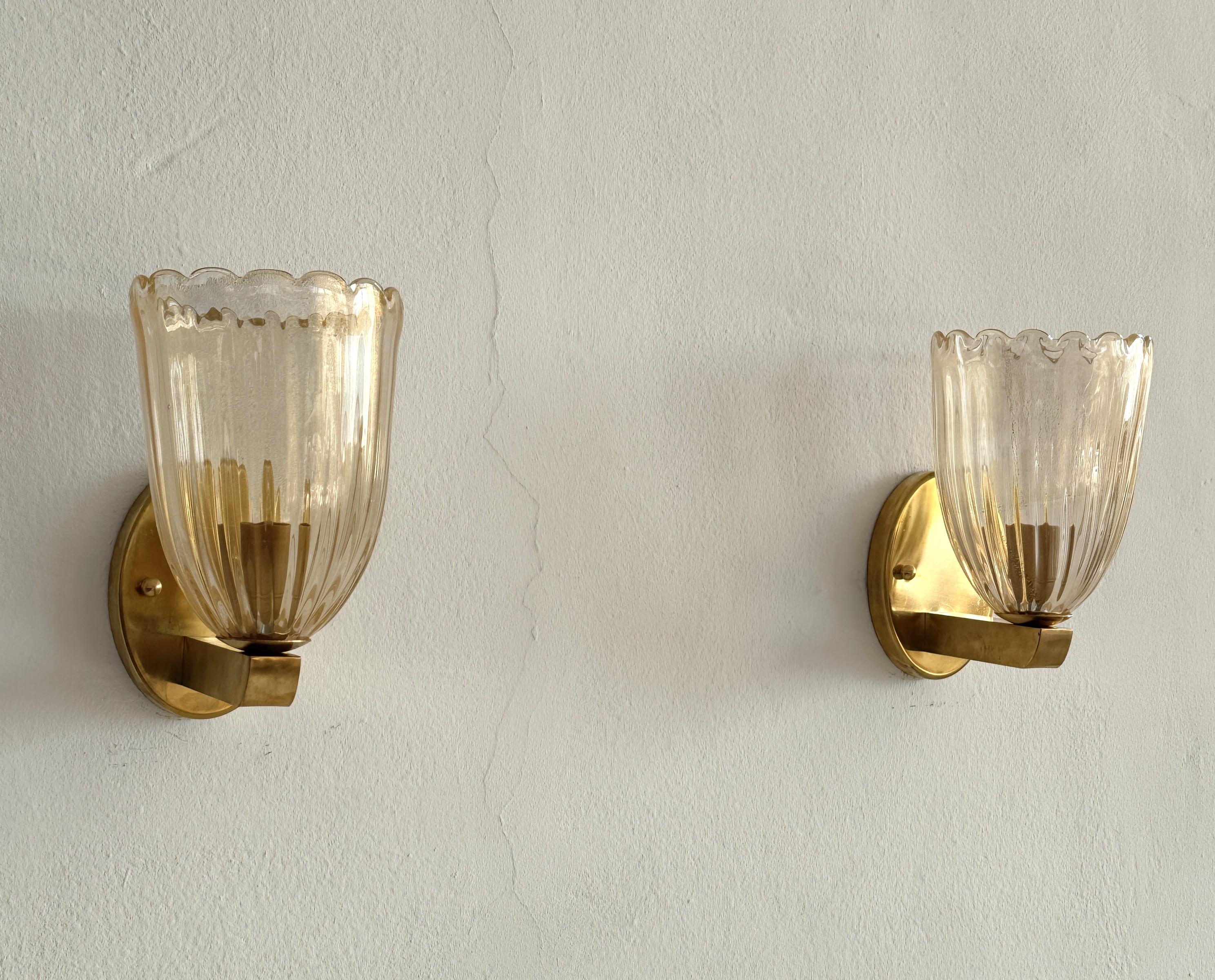 Italian Brass and Murano Glass Wall Lights or Sconces in Art Deco Style, 1990s

Beautiful set of two gorgeous brass wall lamps made of strong brass base and light amber colored Murano glasses with real golden shimmer/glitter inside the glass. Art