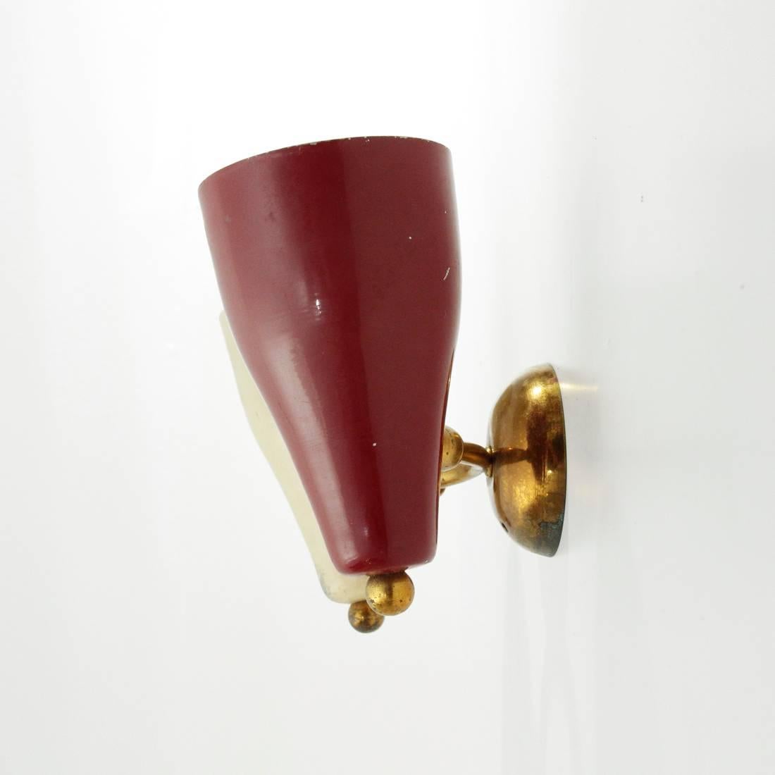 Wall lamp of Italian manufacture produced in the 1950s.
Wall plate in brass.
Brass stem with joint.
Two red and white painted aluminum diffusers with brass details.
Structure in good general condition, paint damaged in some parts.

Dimensions: