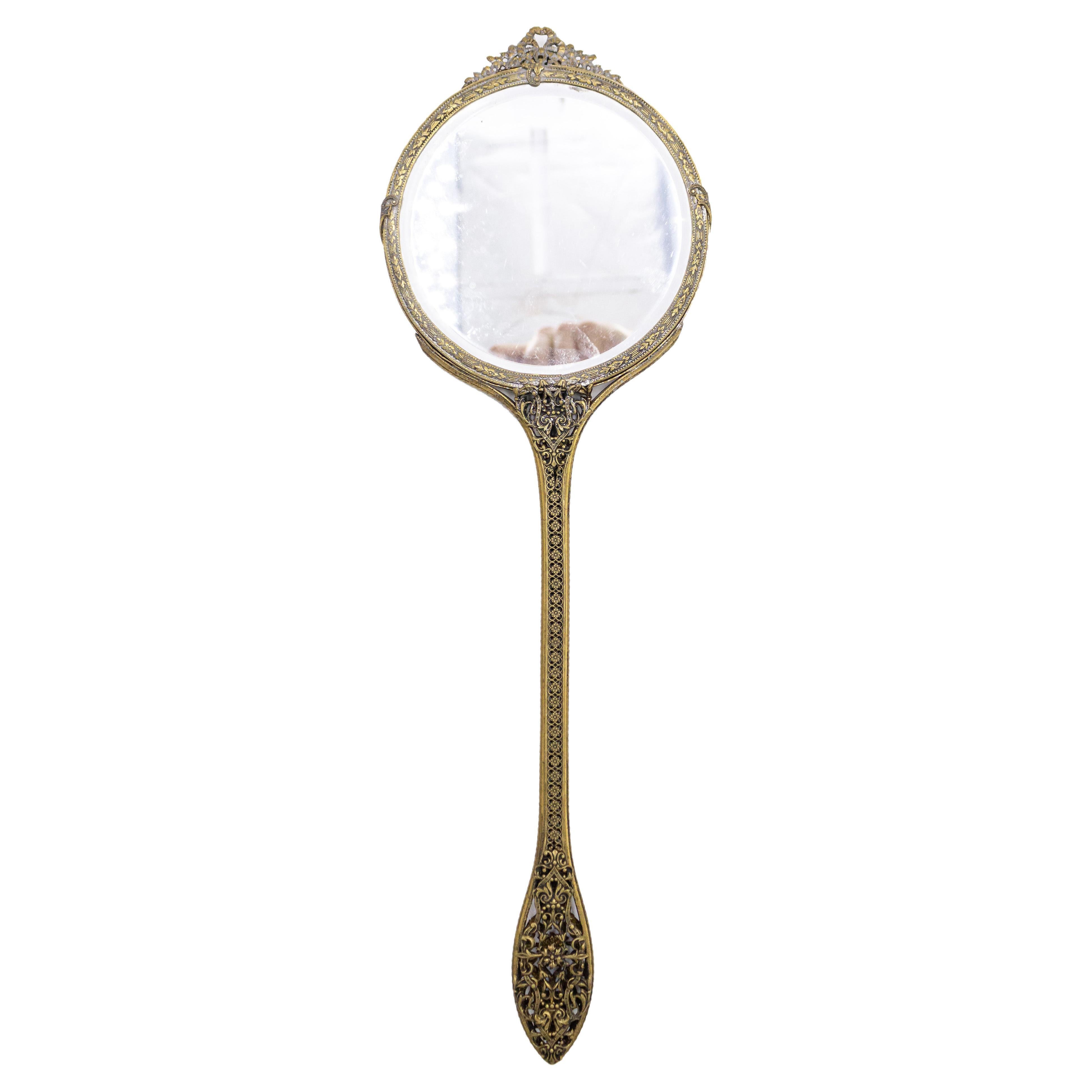 Italian Venetian style brass hand mirror with round Capodimonte porcelain on back and filigree handle (19/20th Century).
 