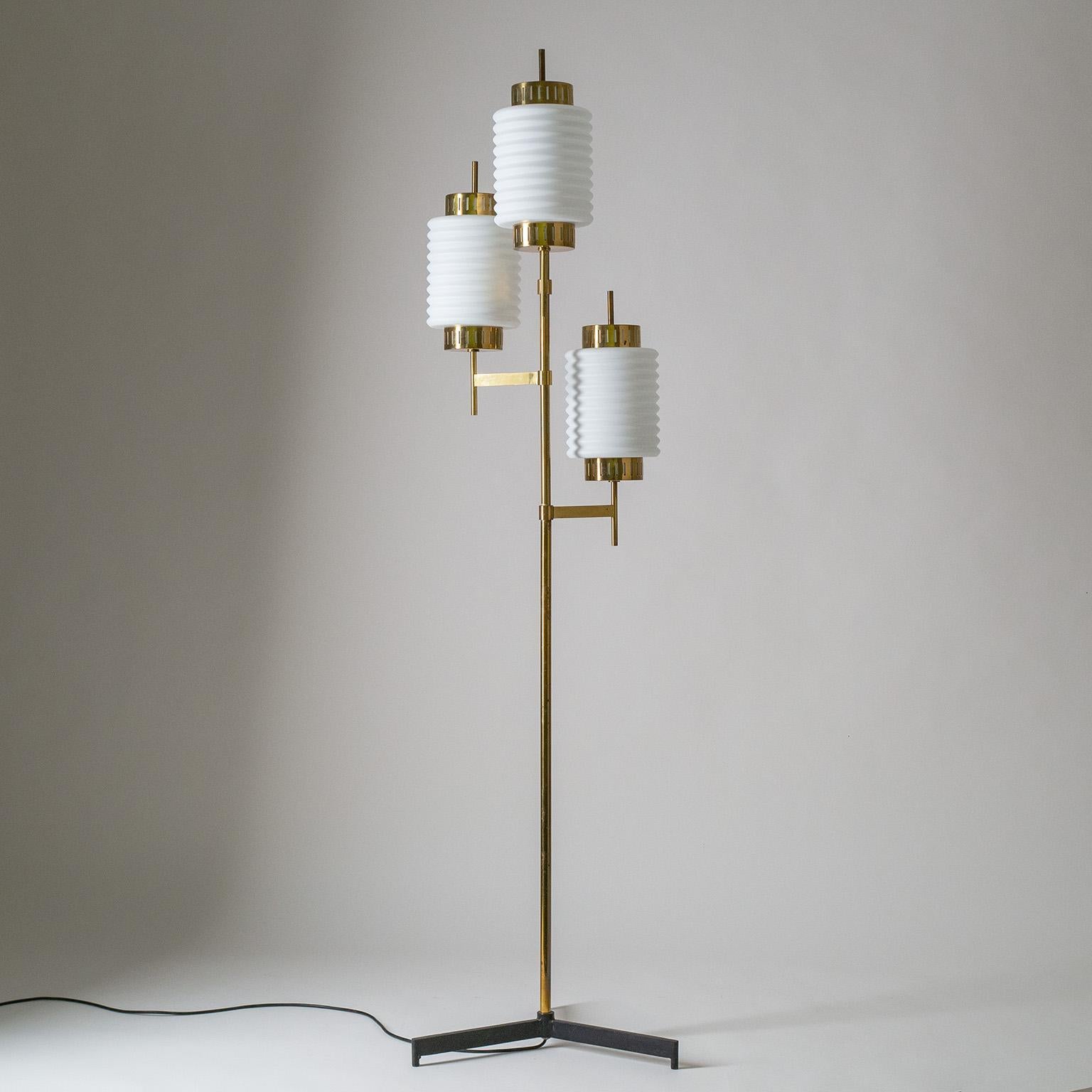 Italian tripod floor lamp in brass with large ribbed satin glass diffusers, circa 1960. Blackened steel base with polished brass body. The ribbed glass diffusers have a thick white inner casing with a satin finish on the outside. Brass and ceramic