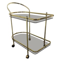 Le chariot de bar italien en laiton et verre fumé des années 1960