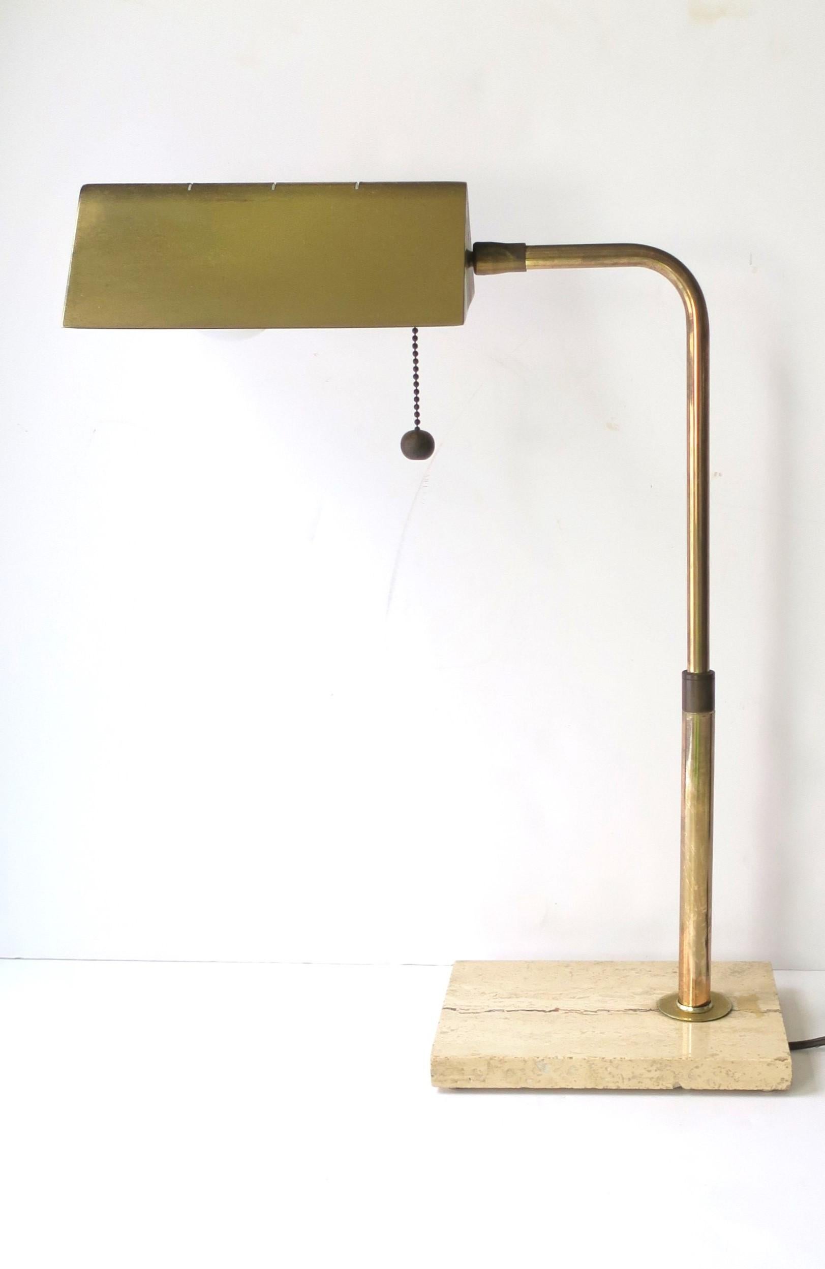 An Italian brass and travertine marble table or desk lamp, circa 1960s, 1970s, mid to late-20th century, Italy. Lamp has flexible shade, easy on/off pull chain with ball, and a rectangular neutral travertine marble base. Lamp would work as a table