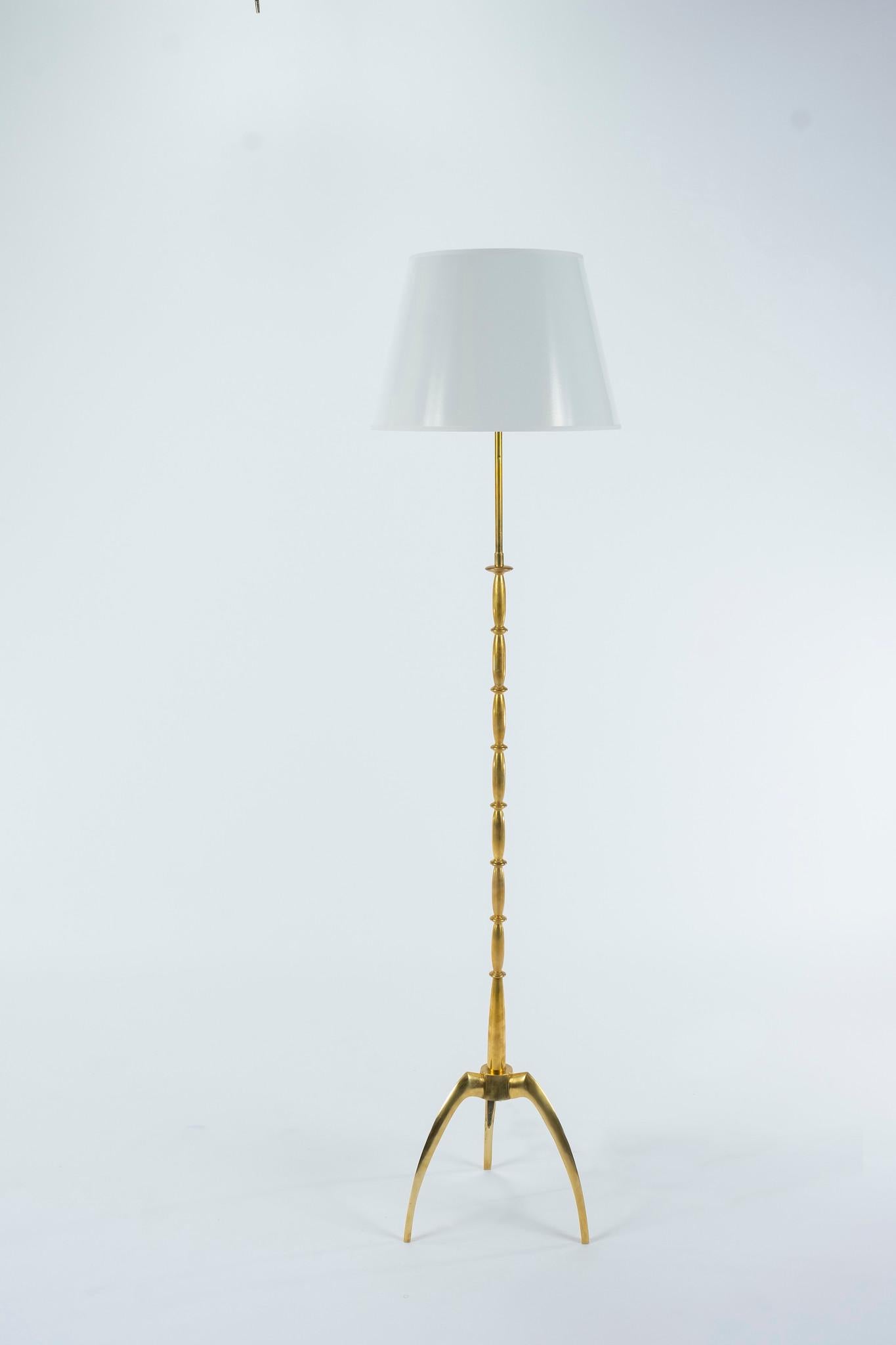 A vintage brass atomic style floor lamp with white paper shade. Styled with spindles atop a trio of legs, two-light with pull chains and newly electrified with UL parts.

Lamp shade dimensions: Top 11