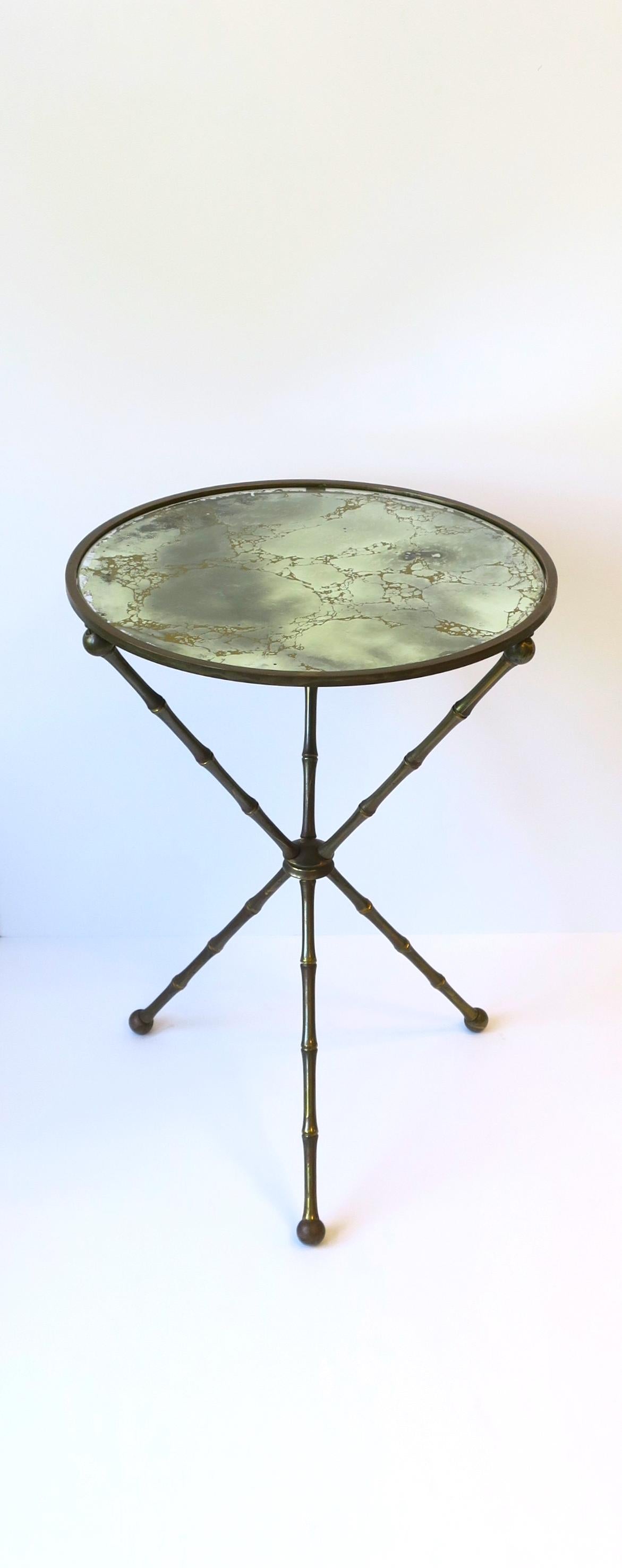 An Italian tripod gueridon round side or drinks table with brass frame in a 'bamboo' design and eglomise mirrored glass top, circa mid-20th century, 1960s, Italy. 

Dimensions: 16.75