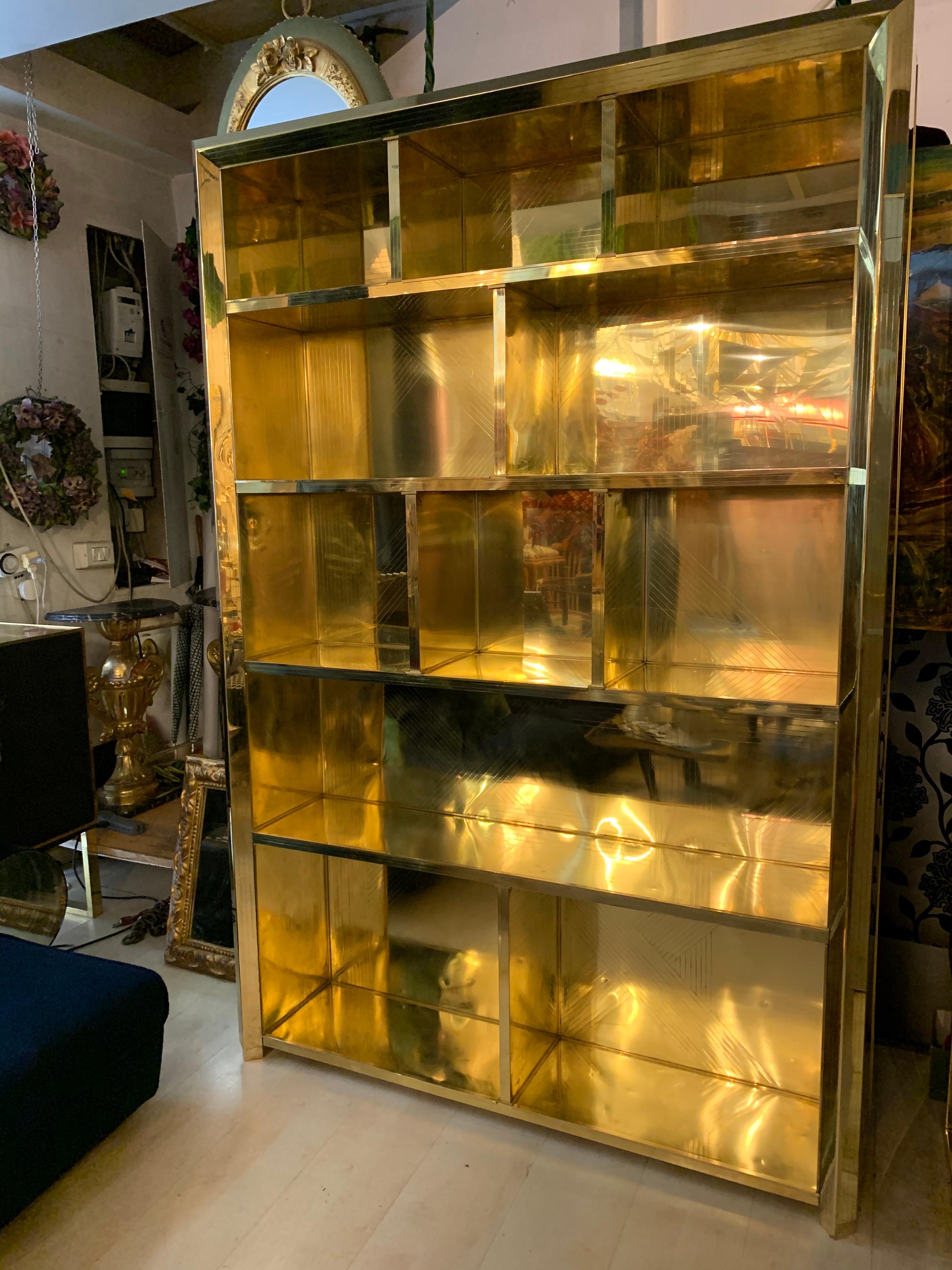 Italian bookcase entirely covered in brass with geometric decoration with striped effect. Unique piece.