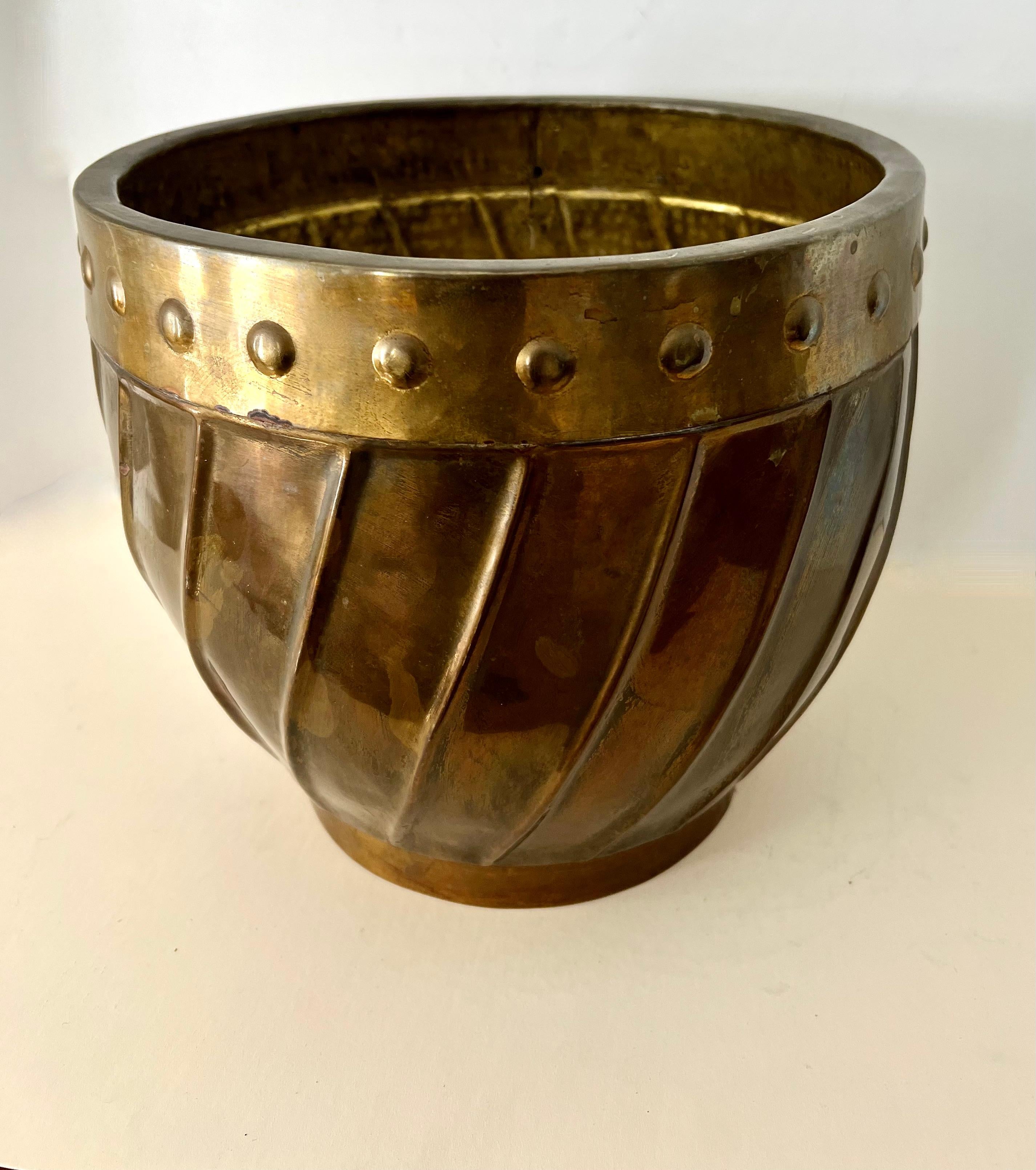 A wonderful Brass jardiniere, planter or Cachepot. The piece has a band with round convex 'button's and a nice swirl pattern below. 

A compliment to any space - could be used as a planter on the floor, on a console or to store things. A great