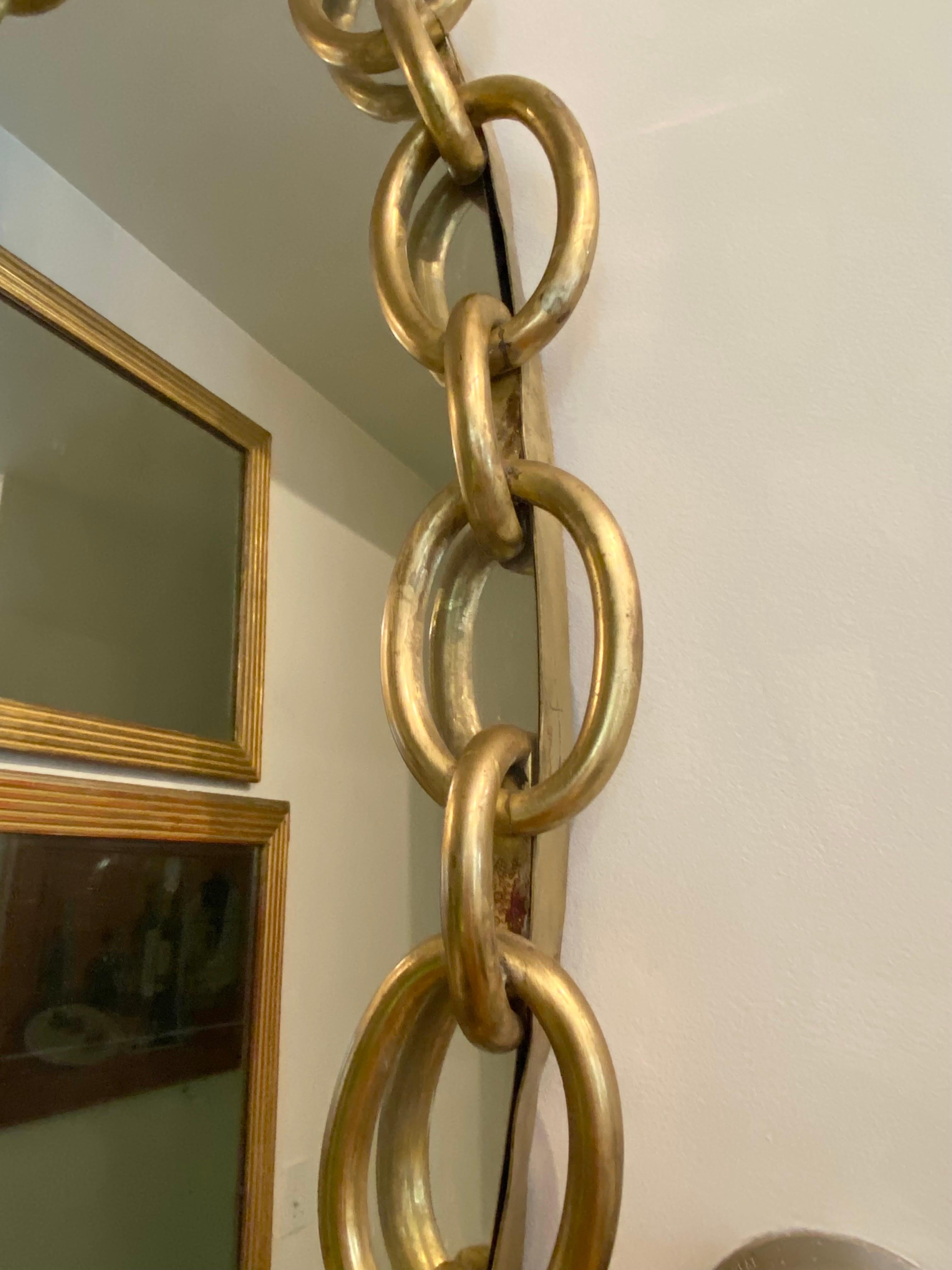 Elegant oval brass chain link framed mirror.