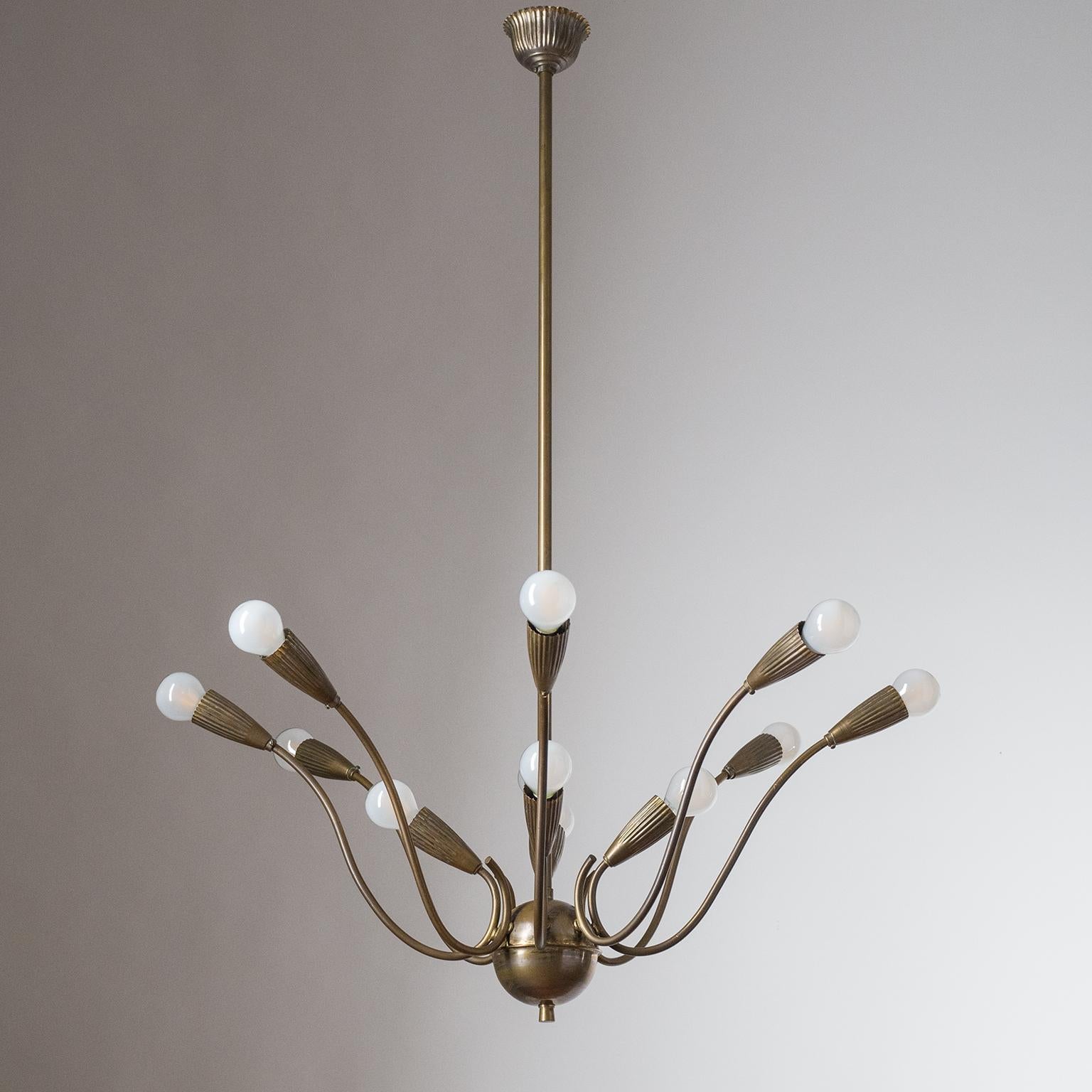 Elegant 12-light Italian brass chandelier attributed to early Stilnovo production, circa 1948. Rare frilled brass socket covers and canopy. Parts of the chandelier (center piece, socket covers and canopy) were probably originally nickel-plated,