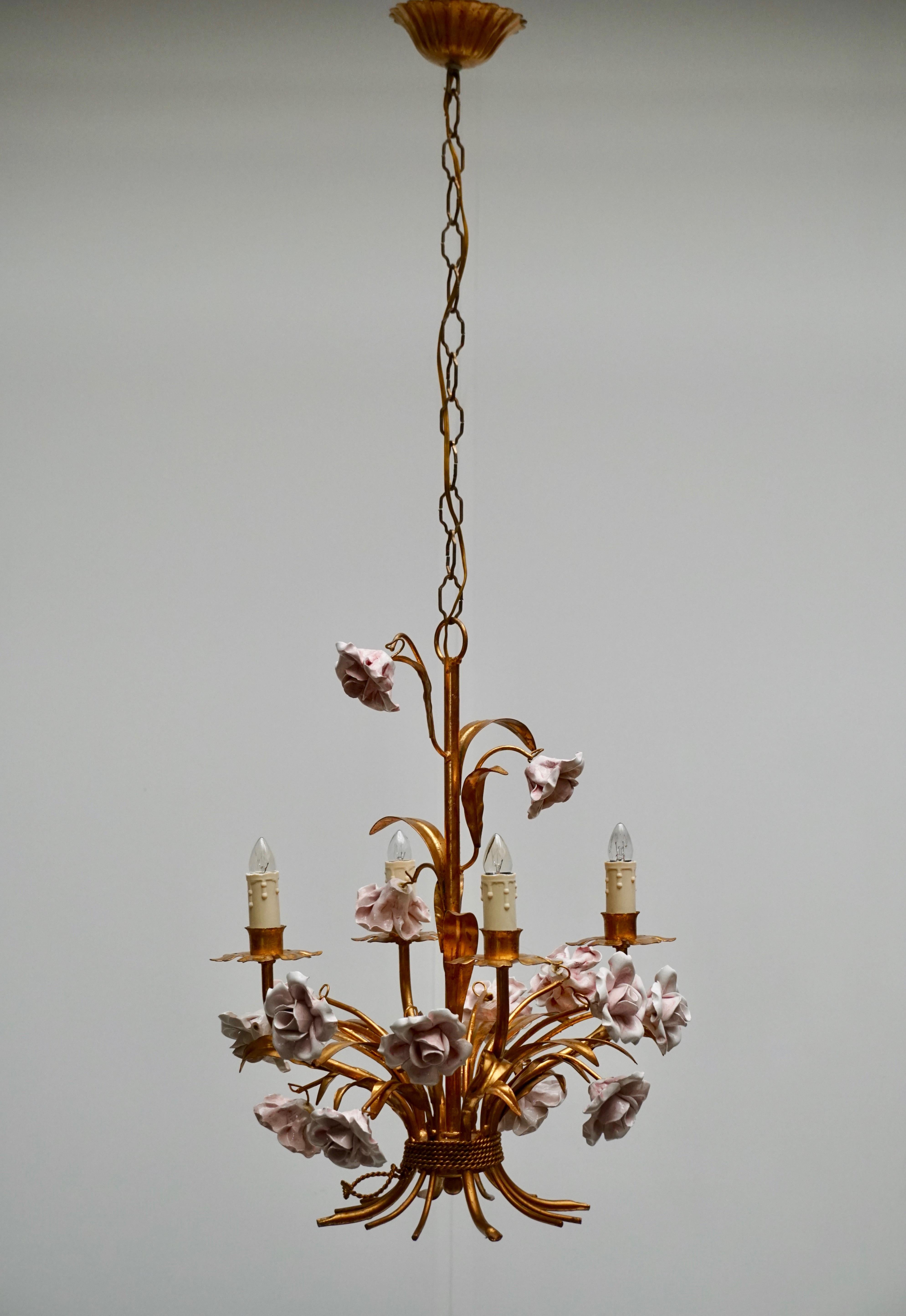 Italian Hollywood Regency brass gilt chandelier with pink porcelain flowers.
Measures: Diameter 40 cm.
Height fixture 52 cm.
The total height including the chain and canopy is 100 cm.