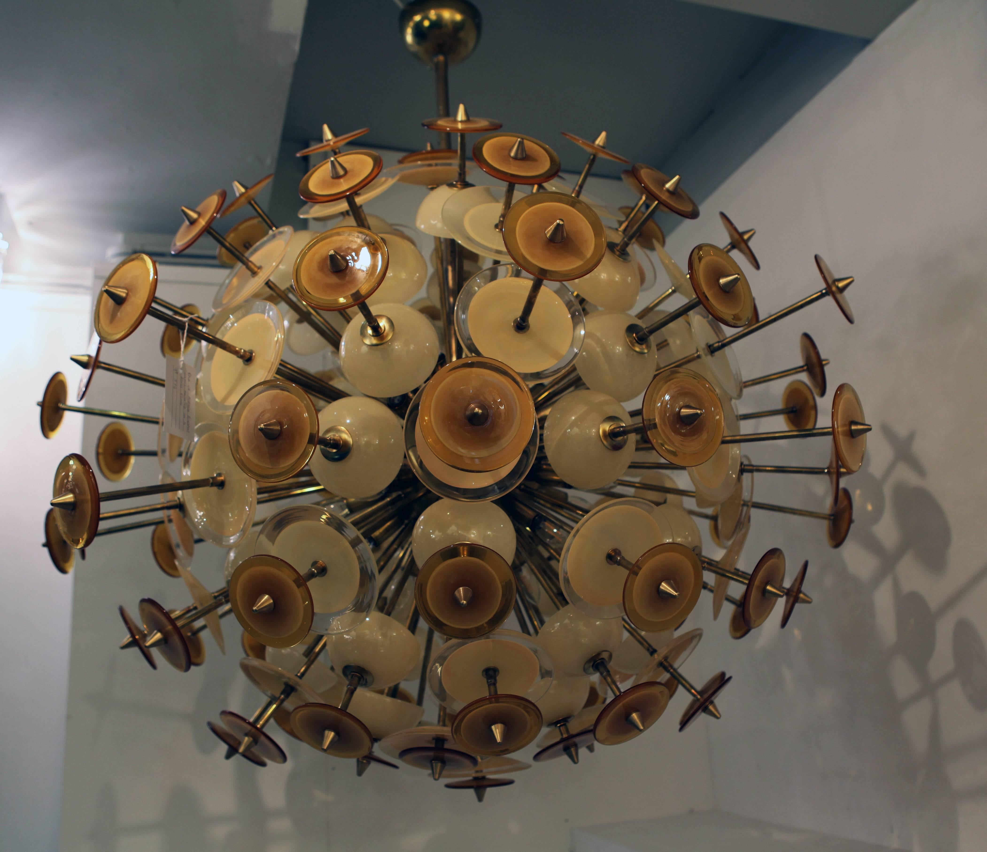 Monumental pair of chandeliers with different shades of colors and dimensions of amber Murano glass mounted on a brass fixture