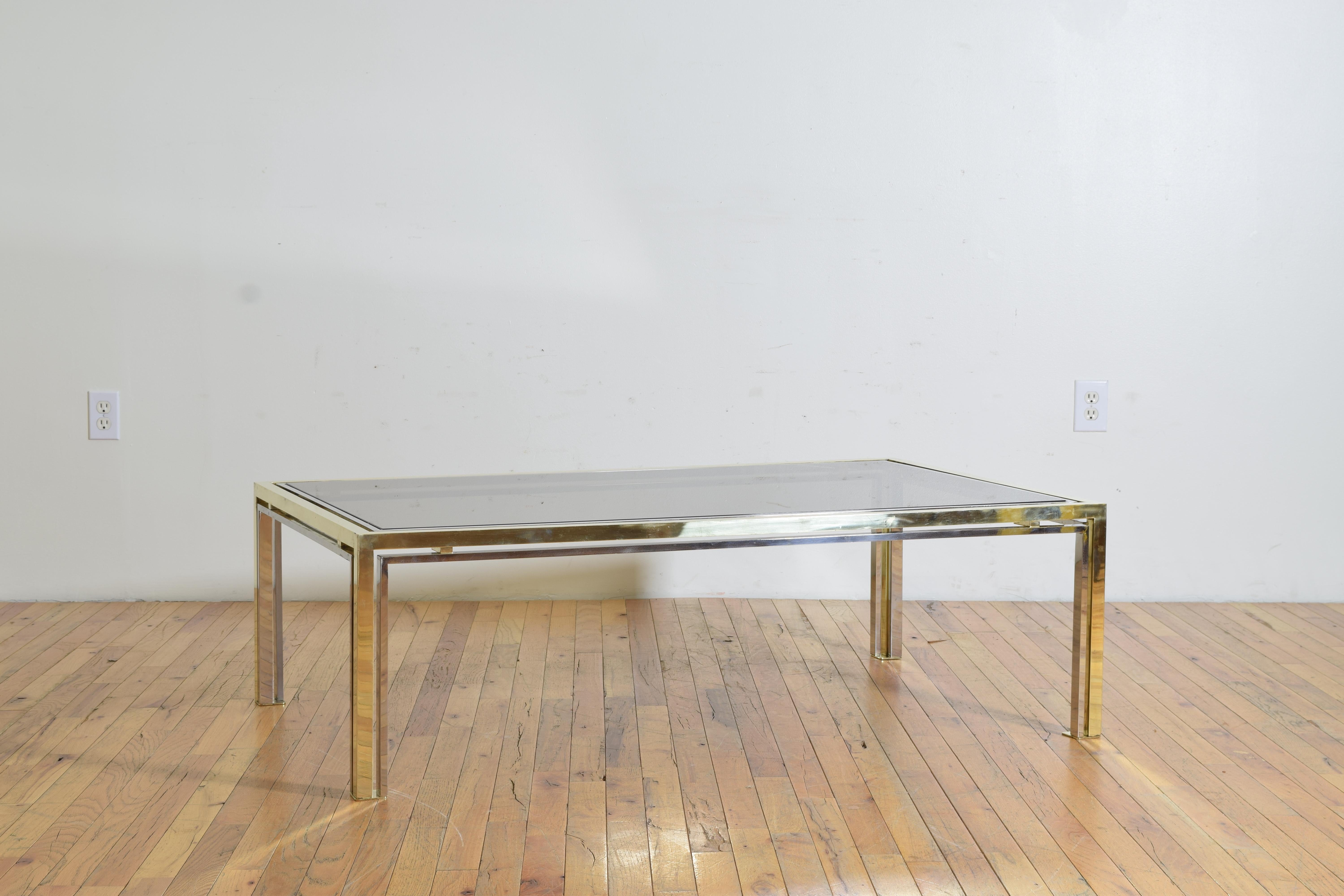 Having an inset glass top within a frame of brass and chrome, raised on straight legs