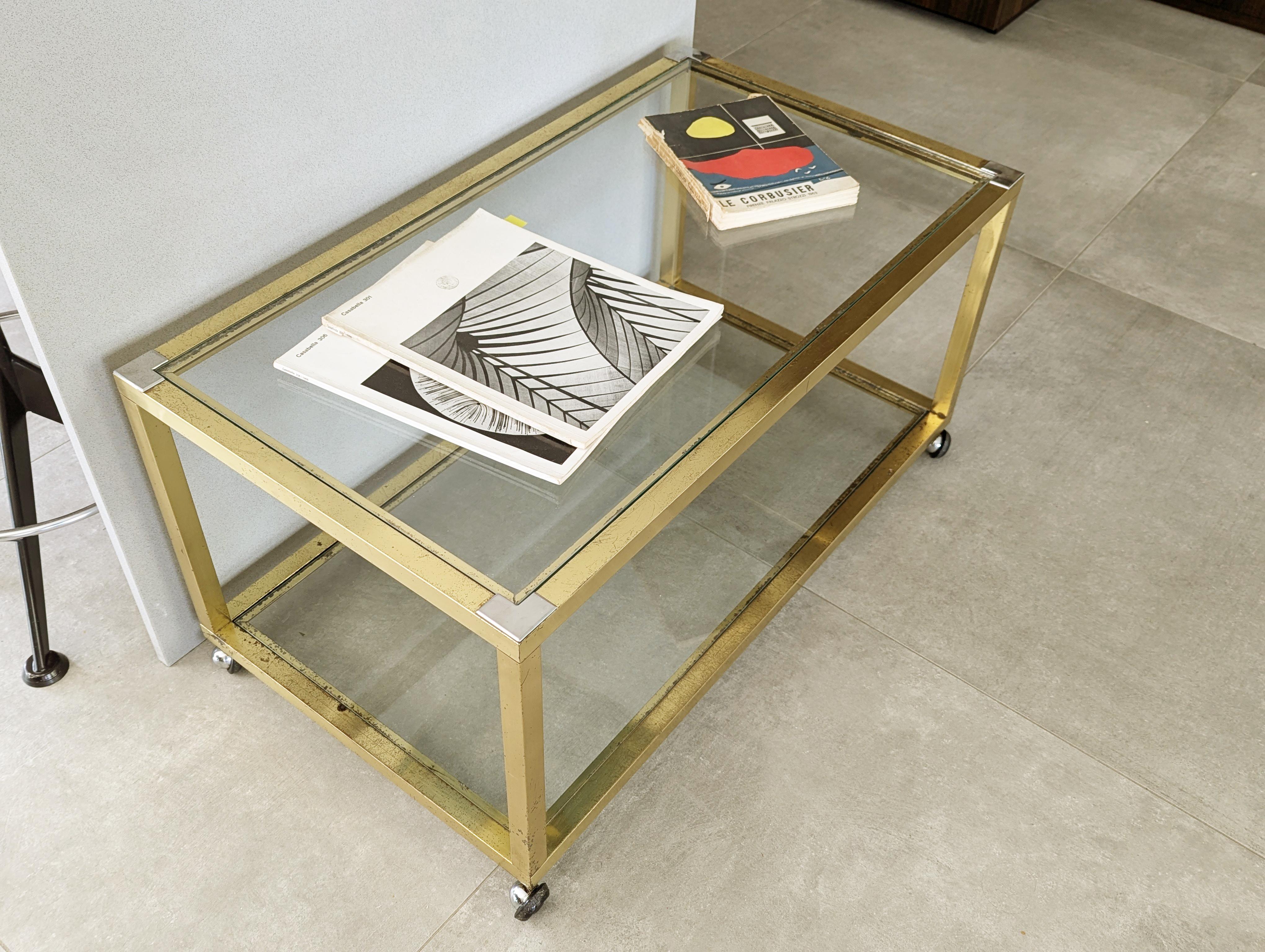 Dieser Vintage-Couchtisch/Beistelltisch wurde in den 1970er Jahren in Italien hergestellt. Sein Design ist sehr minimalistisch mit einer Messingstruktur und 2 herausnehmbaren transparenten Glasböden. Auf der Oberseite, an den Ecken, sind die