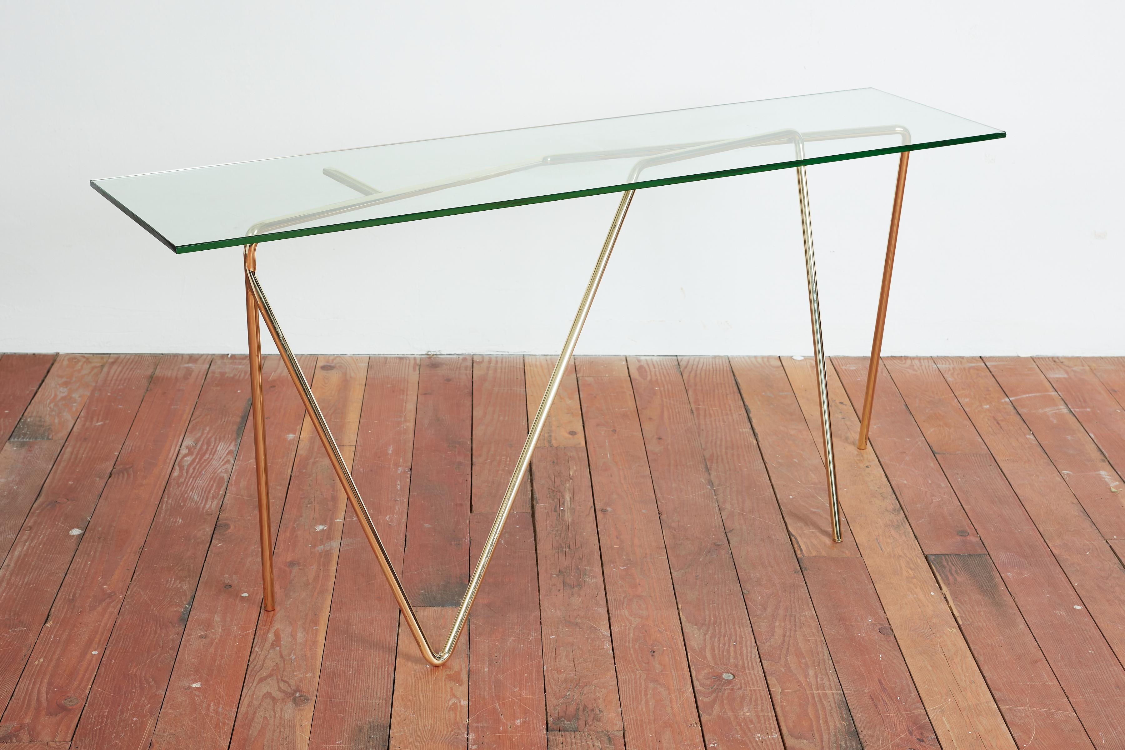 Unique brass and glass Console - Italy 1980's 
Constructed of 2 pieces of tubular steel - newly plated in unlacquered polished brass 
Chic design - and functional 
New piece of glass 