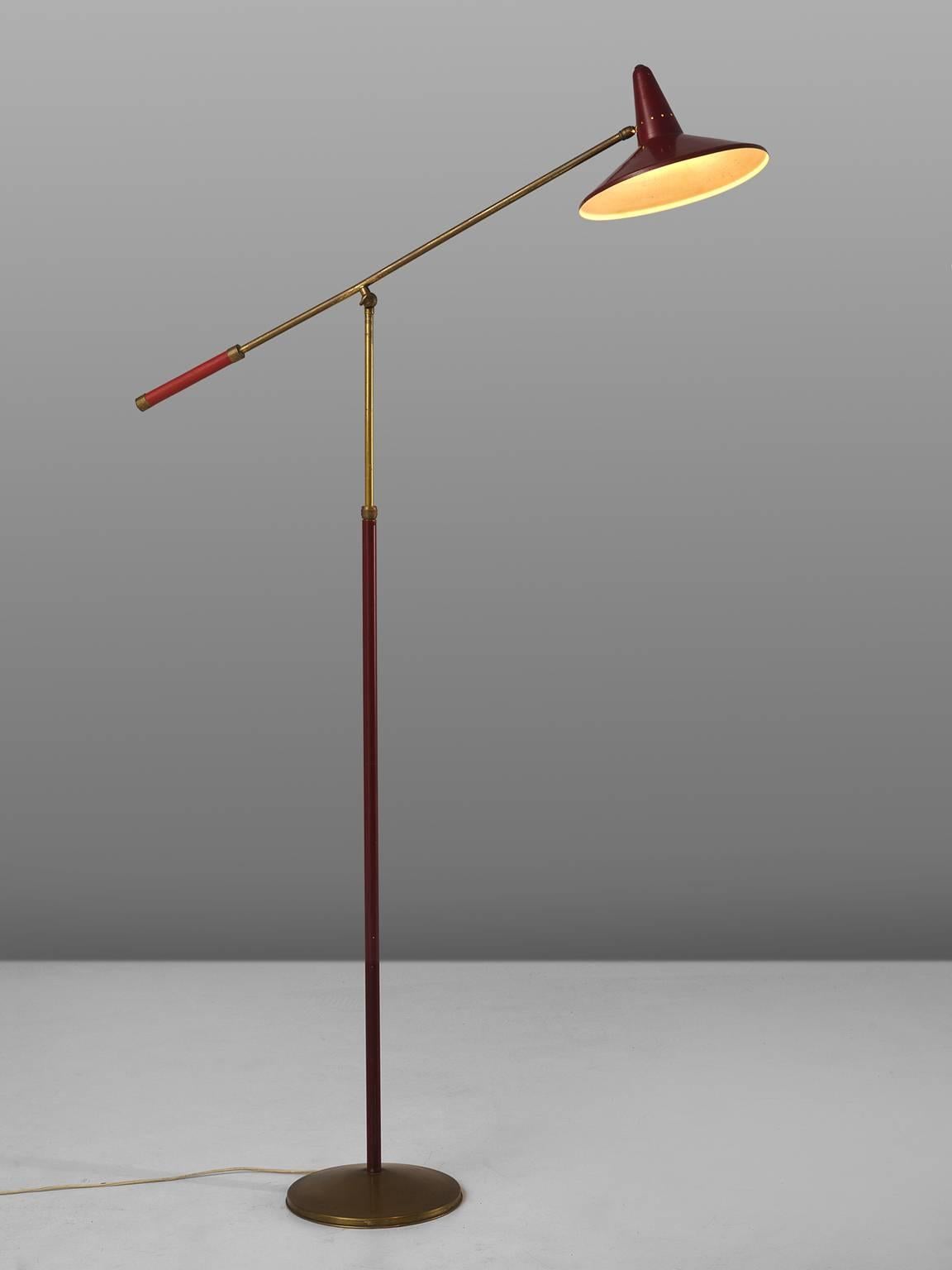 Floor lamp, brass, metal, Italy, 1950s.

This floor lamp with red metal shade and round brass base features elegant and warm details such as the patinated brass that combines perfectly with the deep red coated metal. The shade features a classic