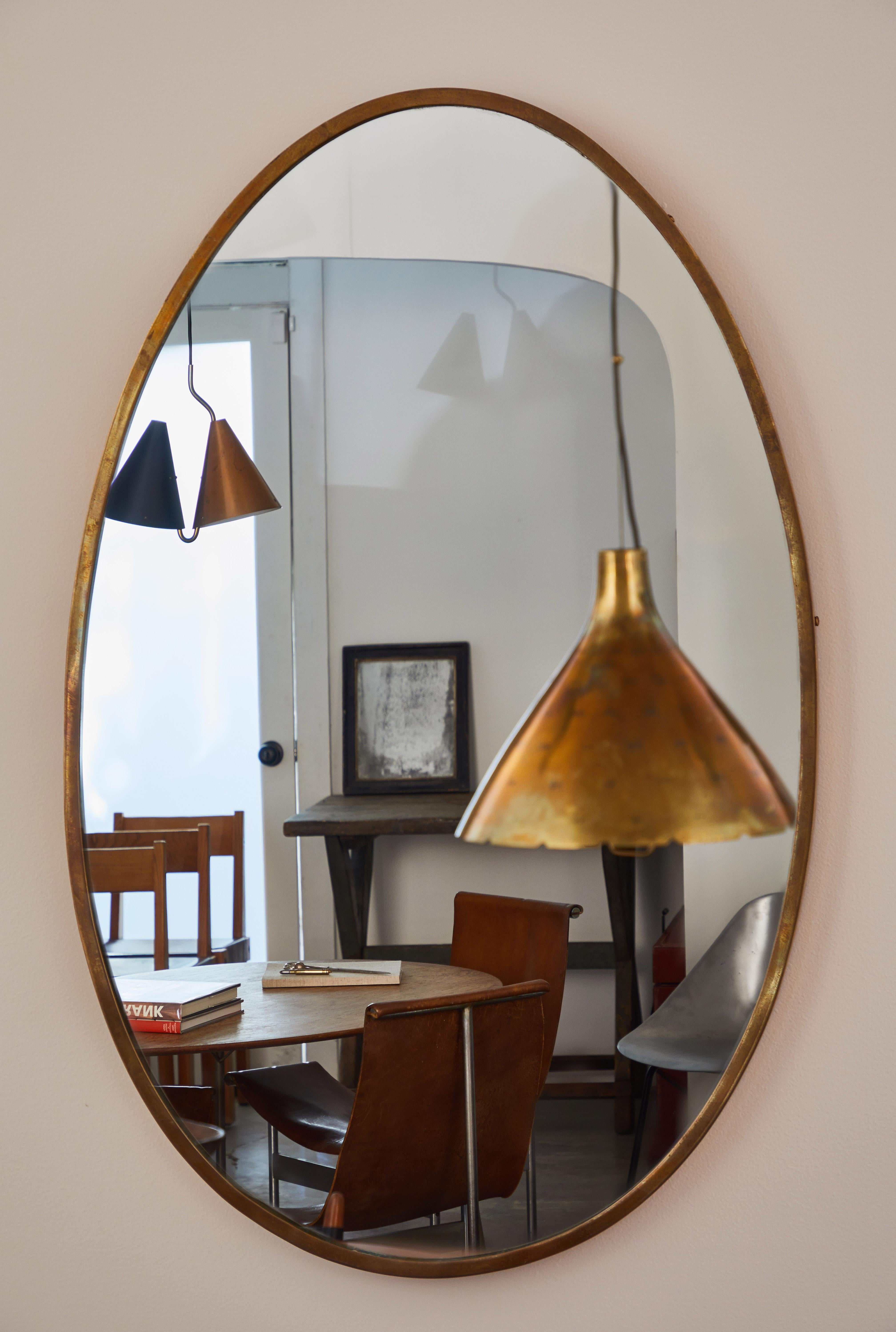 Italian egg shaped brass frame mirror. Made in Italy, circa 1960s.