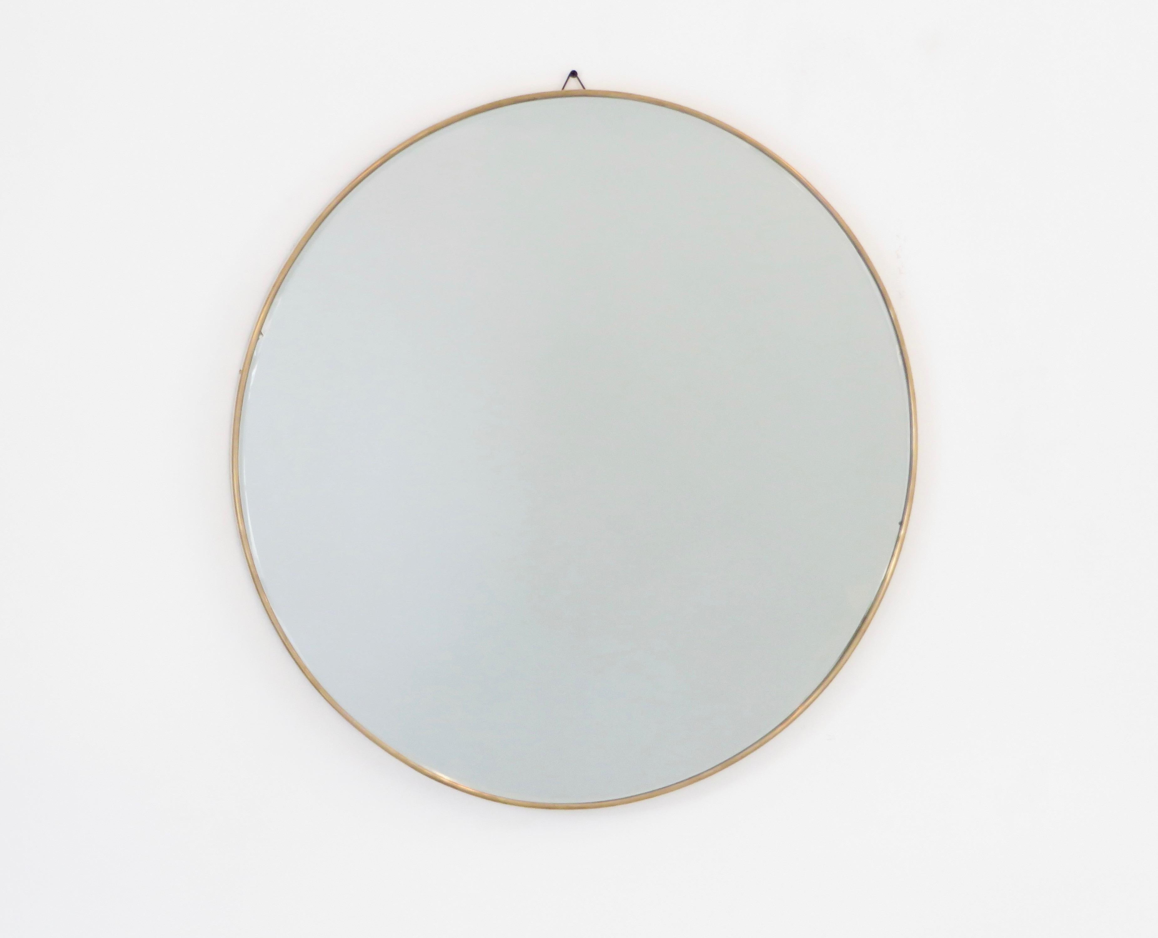 A round Italian vintage brass framed mirror with beautiful patina and no flaws to the original mirror, circa 1950. 
The mirror has a .25 