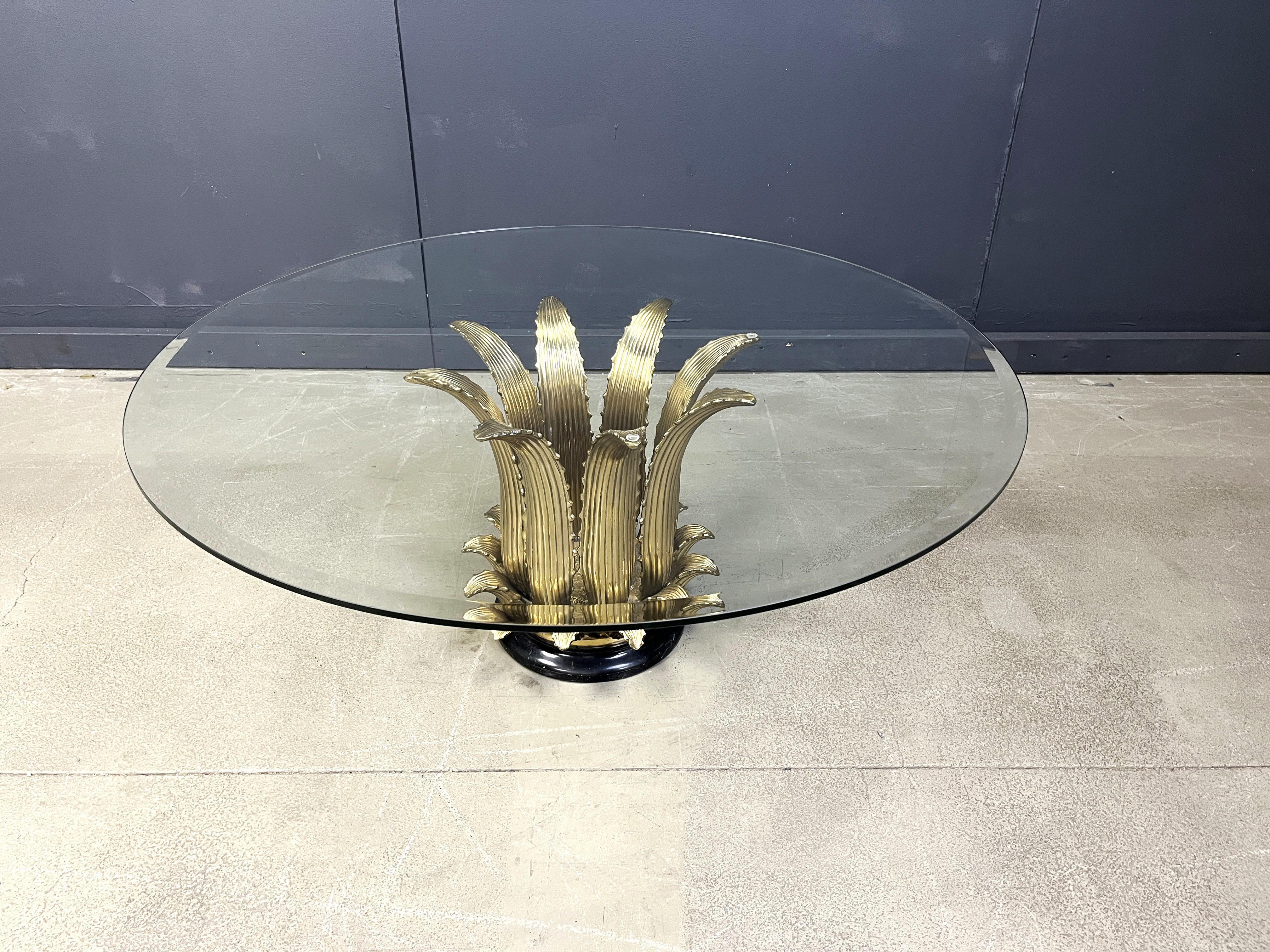 Sculpturale table basse de style hollywood regency italienne présentant des feuilles de laiton montées sur une base de marbre noir et un plateau en verre clair biseauté.

Années 1970 - Italie

Très bon état.

Les diémensions :
Hauteur : 46