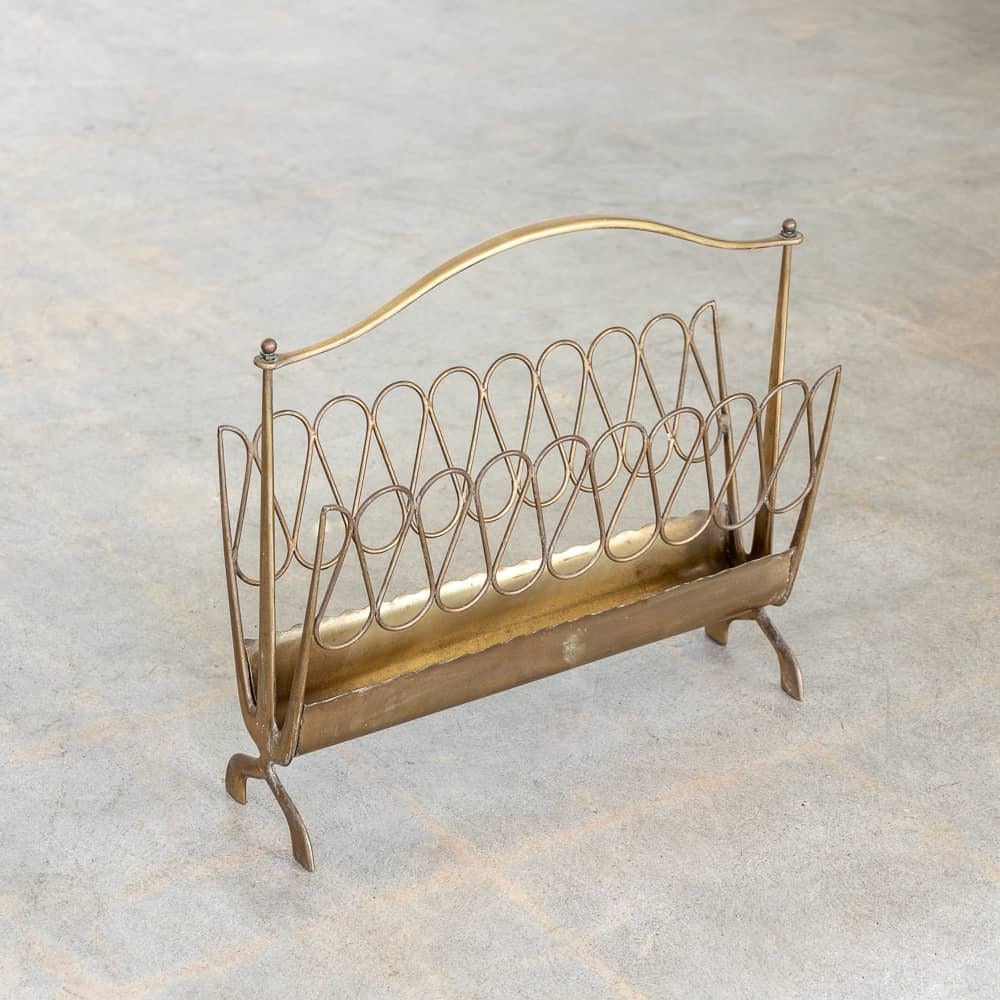 Beautiful sculptural brass magazine rack from Italy, 1950s. Scallop detail on base with loop design on the sides, and a curved brass handle.  Original brass finish shows nice age and patina.