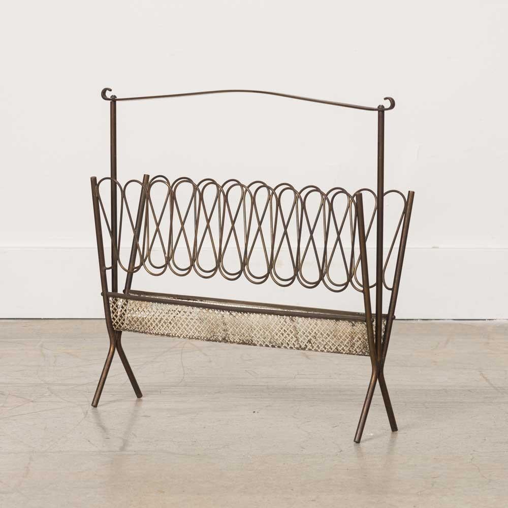 Beautiful sculptural brass magazine rack from Italy, 1950s. Scallop detail on perforated base with loop design on the sides, and a curved brass handle.  Original brass finish shows nice age and patina.