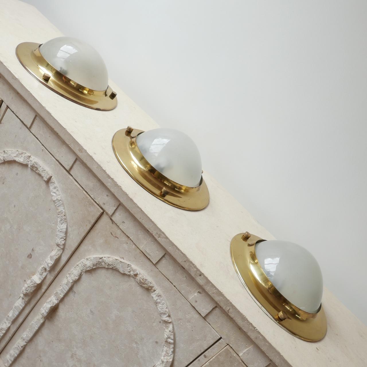A run of three matching brass and etched glass wall or ceiling lights,

Italian, circa 1960s.

Attributed to Luigi Caccia Dominioni as the 'Tommy' model.

The lights can be used for the wall but lend themselves more to ceiling lights because