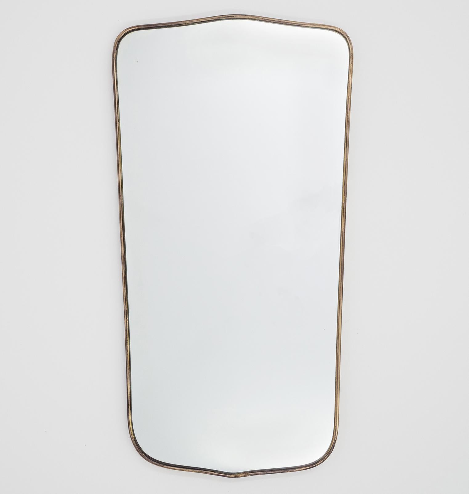 Fine Italian brass mirror from the 1950s. Slender, slightly tapered design with original, silvery tinted mirror. There is a lovely patina on the brass and a few specks and light scratches on the mirror. Width on the bottom is 13.4 inches/34 cm.