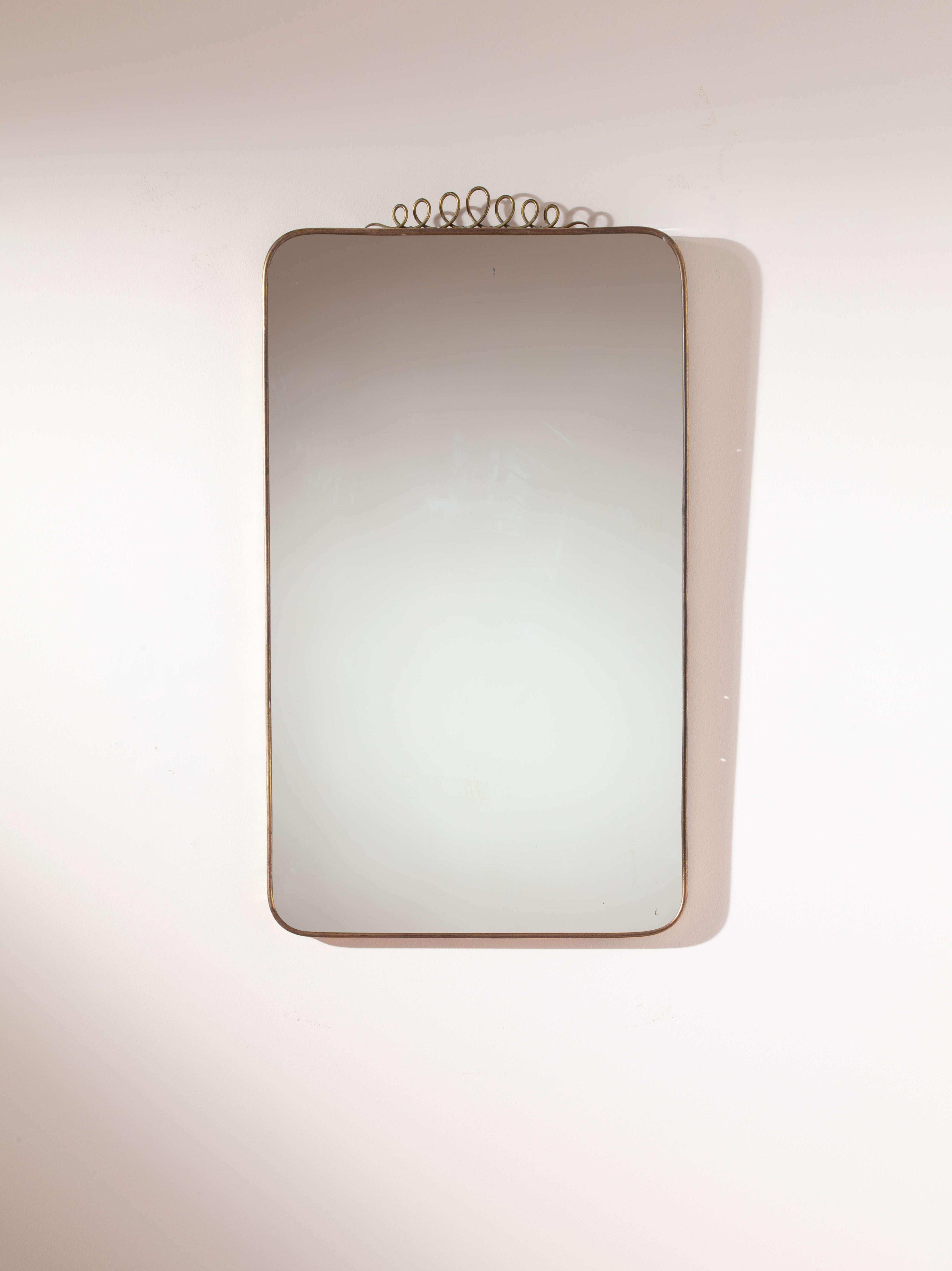 Brass mirror in the style of Gio Ponti, featuring a polished brass frame and mirrored crystal, Italian craftsmanship, 1960s

The mirror, an object of allure, a symbol of vanity, and an essential element of interior design capable of adding character