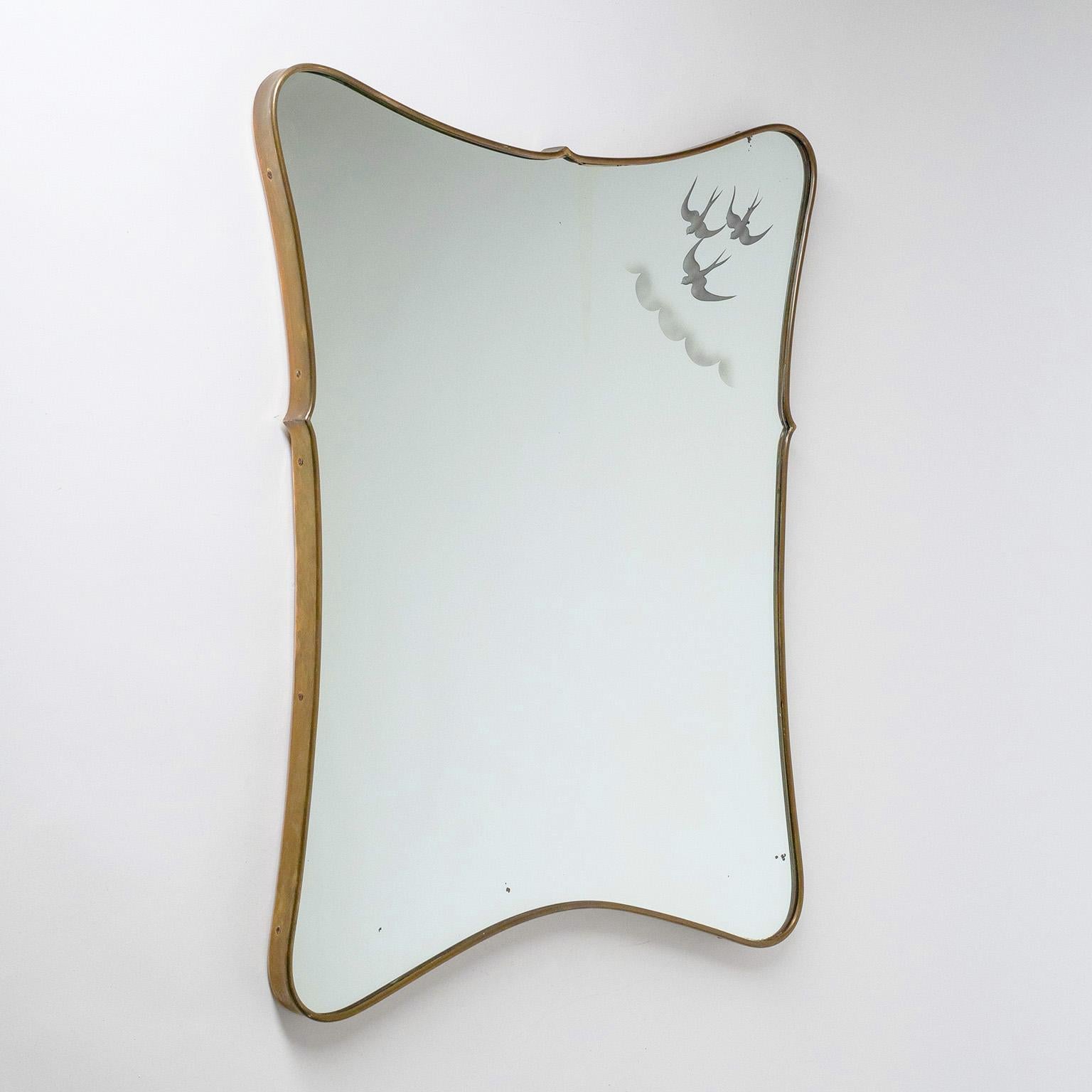 Rare Italian brass mirror from the 1940-1950s. Continuous brass frame with a tapered shape. The mirror has a charming etched or printed decor in the upper right-hand side, depicting three birds in flight amid hints of clouds. Patina on the brass and
