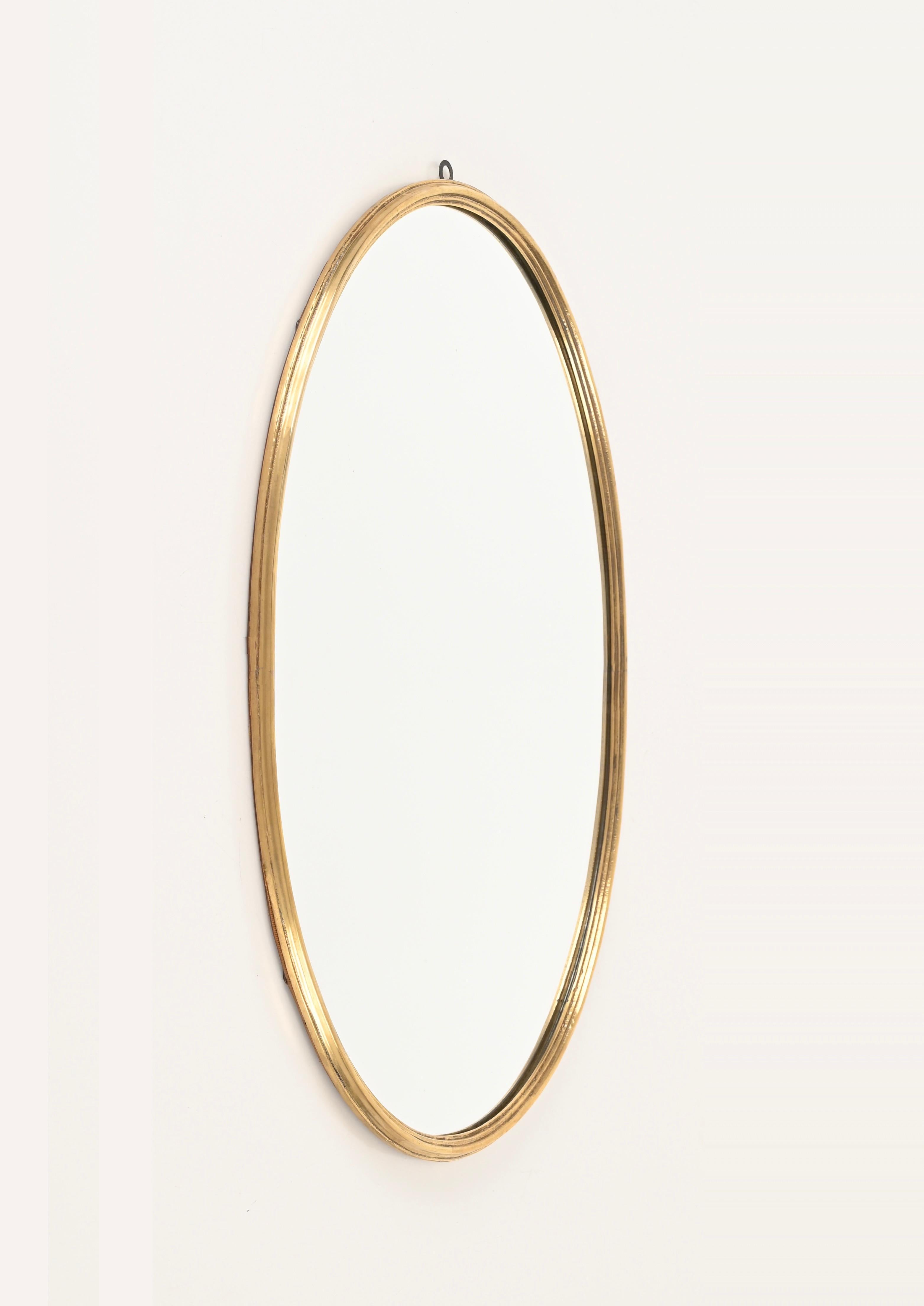 Stunning oval mirror with solid brass frame. This elegant mirror was made in Italy during the 1950s.

This beautiful mirror has an oval frame made in solid brass, which makes it pretty heavy. The brass has a wonderful patina which has not been