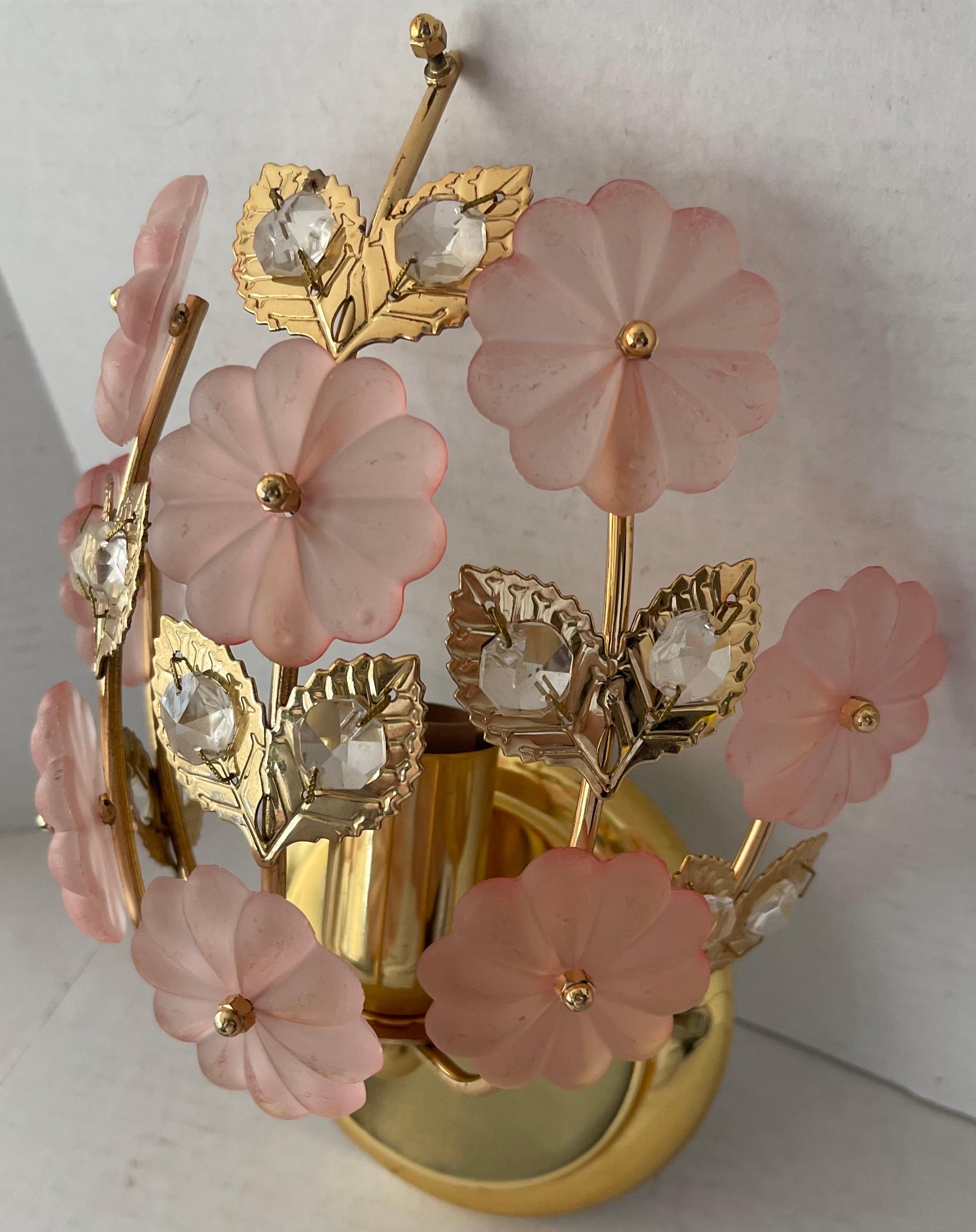 Applique singola in vetro rosa e ottone. Rosette di fiori in vetro rosa smerigliato e cristalli trasparenti attaccati al corpo in ottone lucido. La piastra posteriore rotonda in ottone ha un diametro di 5