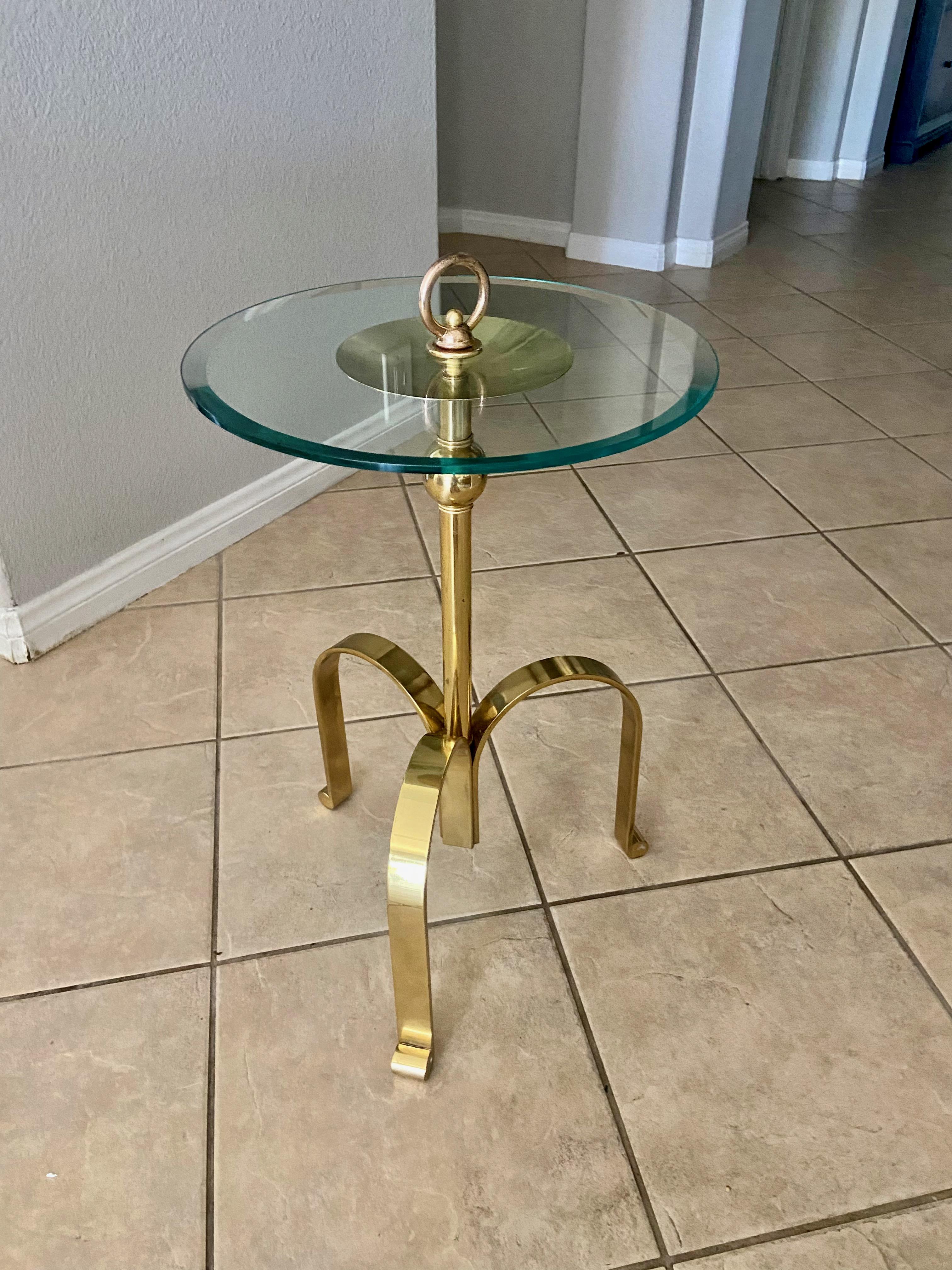 Italian tripod solid brass tripod side or end table with round glass top. The brass table has decorative unique features, and is well constructed using heavy solid brass. 

 