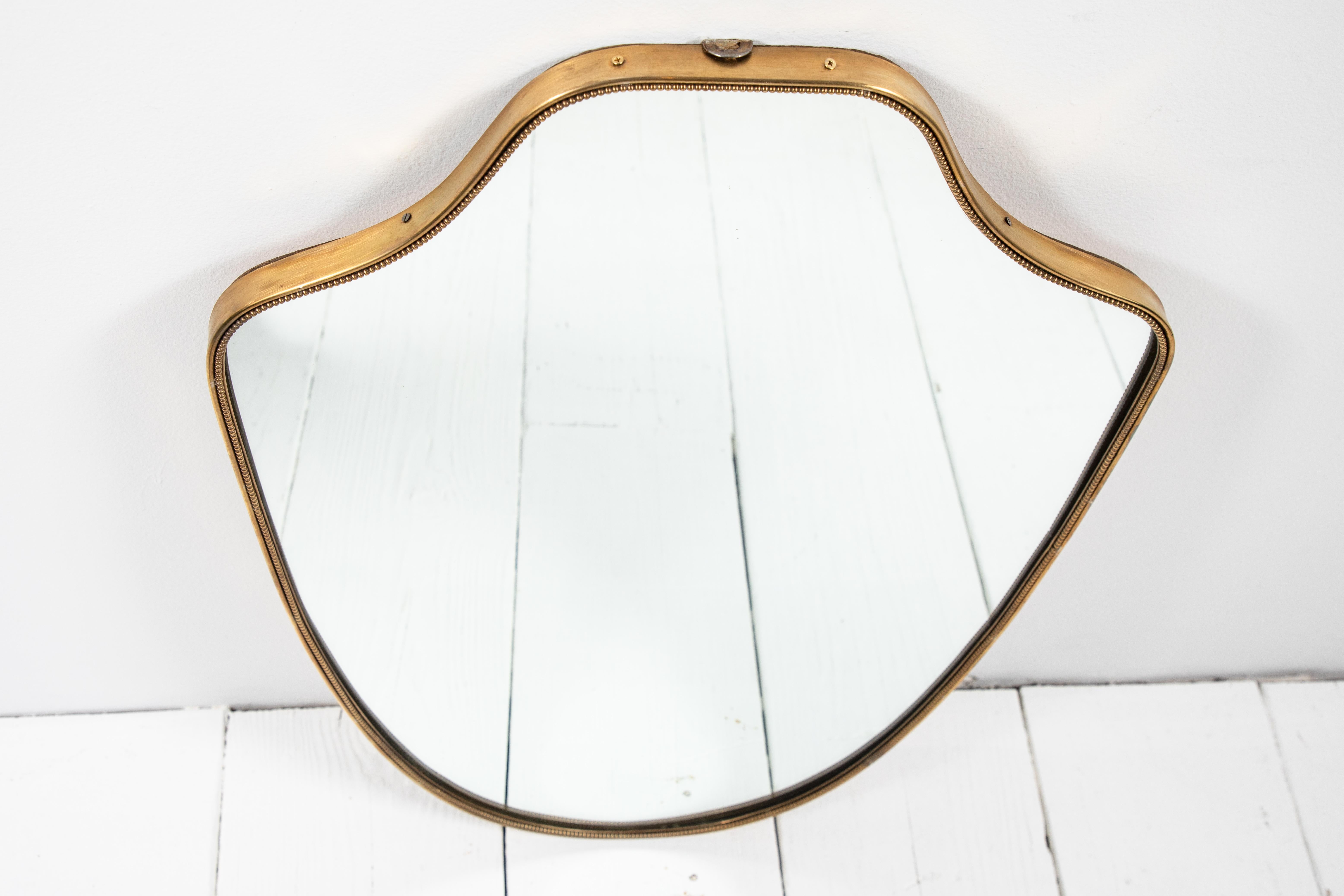 Italian brass shield mirror with beaded details.