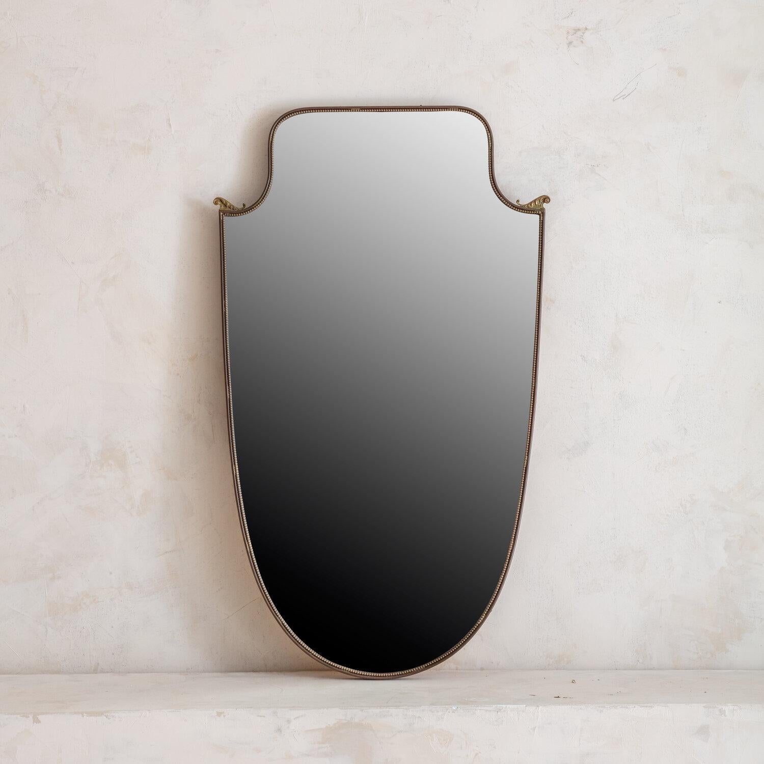 Italian brass shield mirror with corner details.